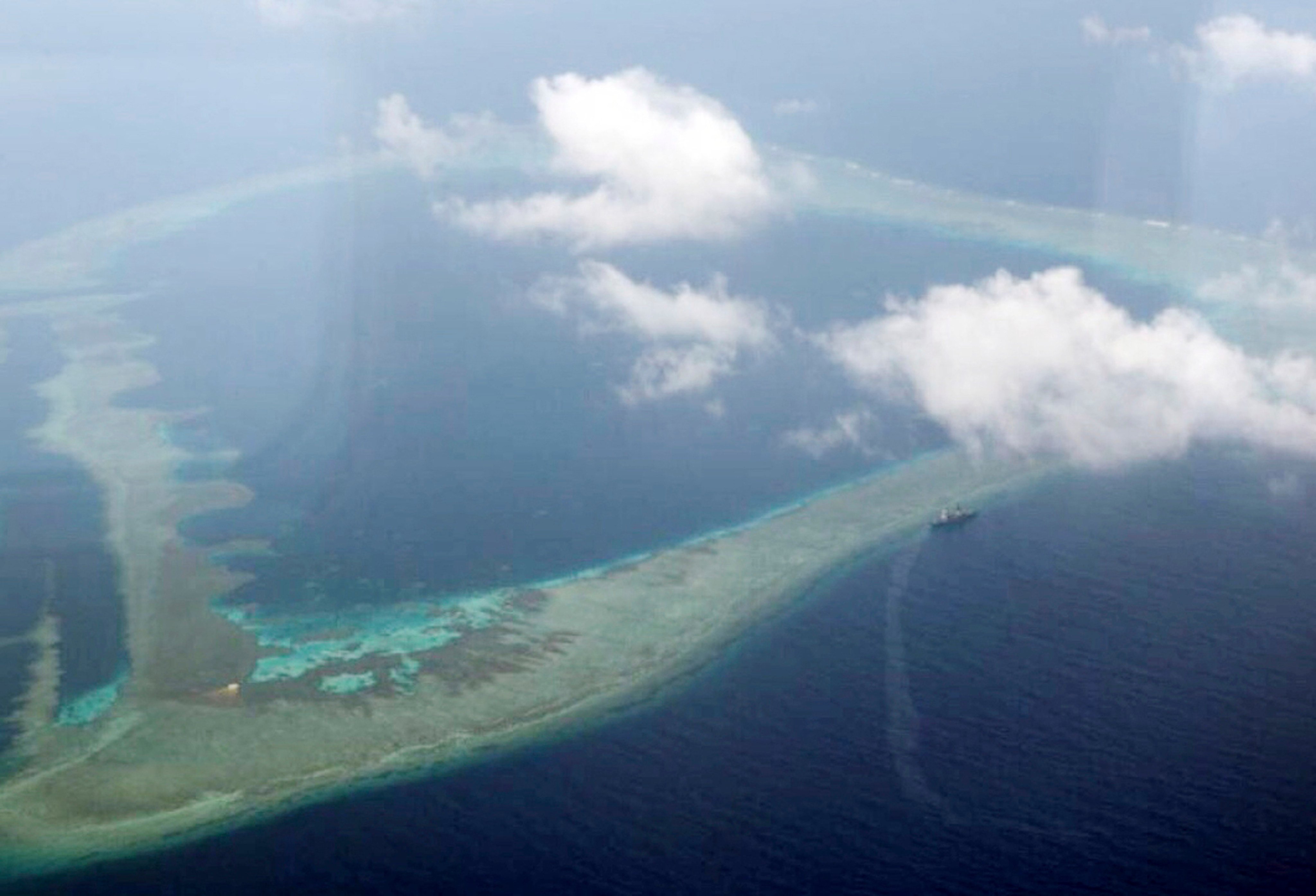 FILE - In this Aug. 31, 2018, file photo provided by the Armed Forces of the Philippines, the Philippine Navy ship BRP Gregorio del Pilar is seen at center right after it ran aground during a routine patrol, on Aug. 29, in the vicinity of Half Moon Shoal, which is called Hasa Hasa in the Philippines, off the disputed Spratlys Group of islands in the South China Sea. Philippine officials say they notified China about a navy frigate that ran aground near a hotly disputed area of the South China Sea in hopes of avoiding any misunderstandings. (Armed Forces of the Philippines via AP, File)