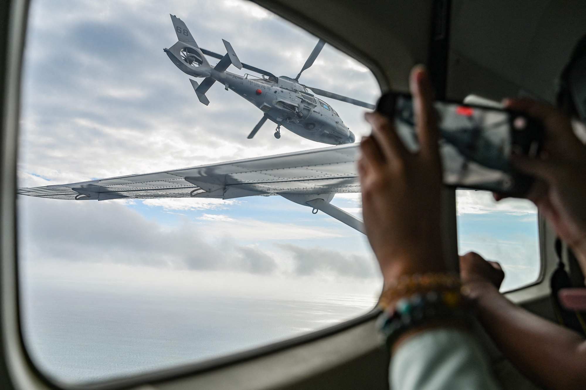 A Chinese navy helicopter flies near a Philippine plane at Scarborough Shoal in the South China Sea in February. Photo: AFP A Chinese navy helicopter flies near a Philippine plane at Scarborough Shoal in the South China Sea in February. Photo: AFP