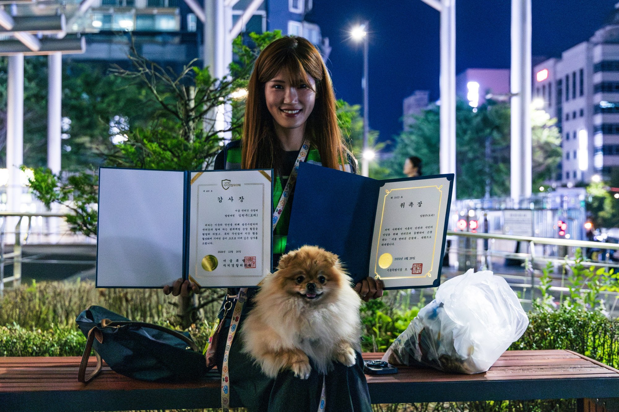 Volunteer Lim Joo-won holds up an appreciation award that her dog Tori has won for contributing to the safety of their neighbourhood in Seoul. Photo: Kim Jung-yeop