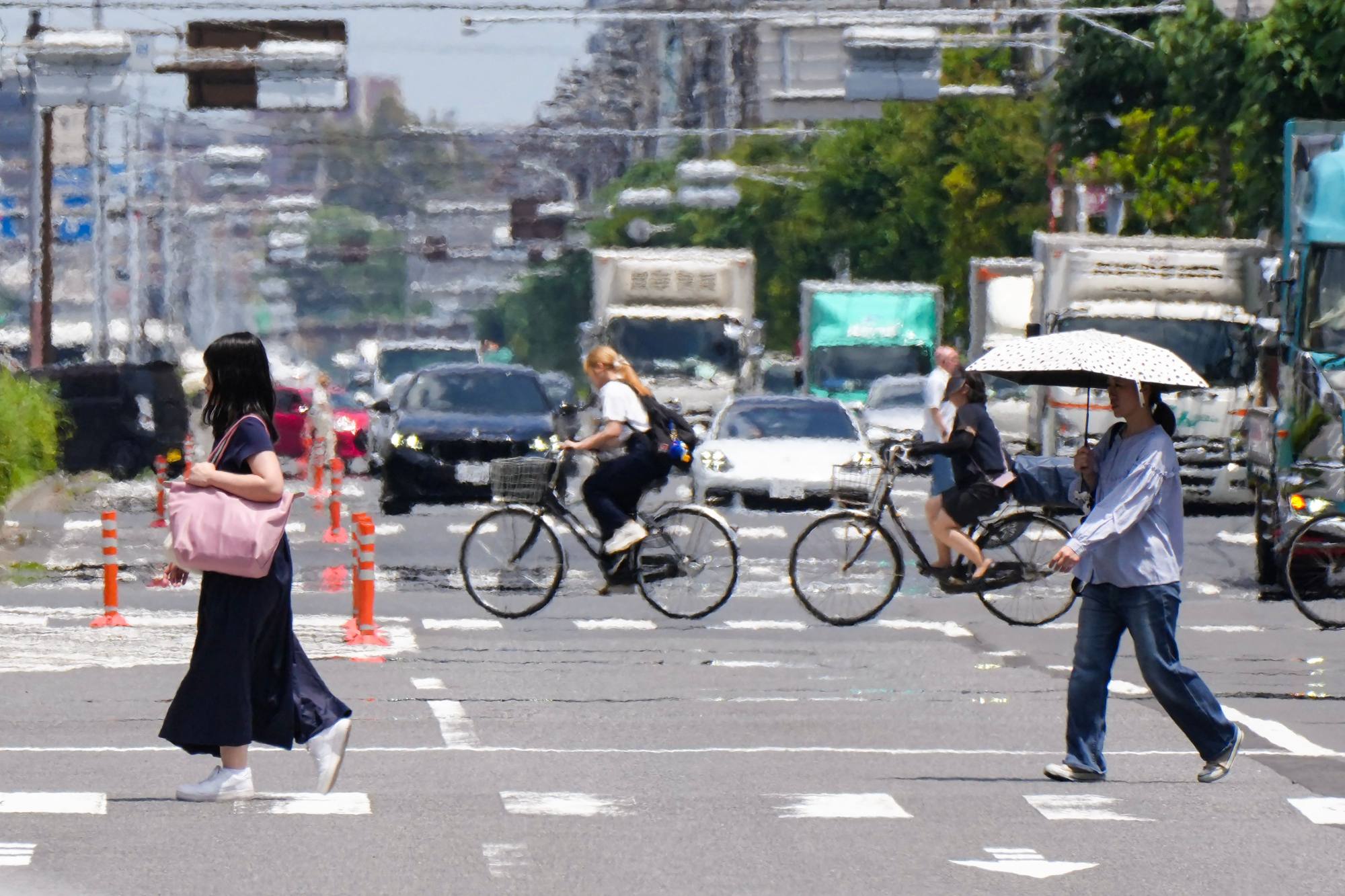 People cross a street under the hot sun in Tokyo on Friday. The heatwave has broken records across Japan, with 14 weather stations logging historic high temperatures in June alone. Photo: AFP People cross a street under the hot sun in Tokyo on Friday. The heatwave has broken records across Japan, with 14 weather stations logging historic high temperatures in June alone. Photo: AFP