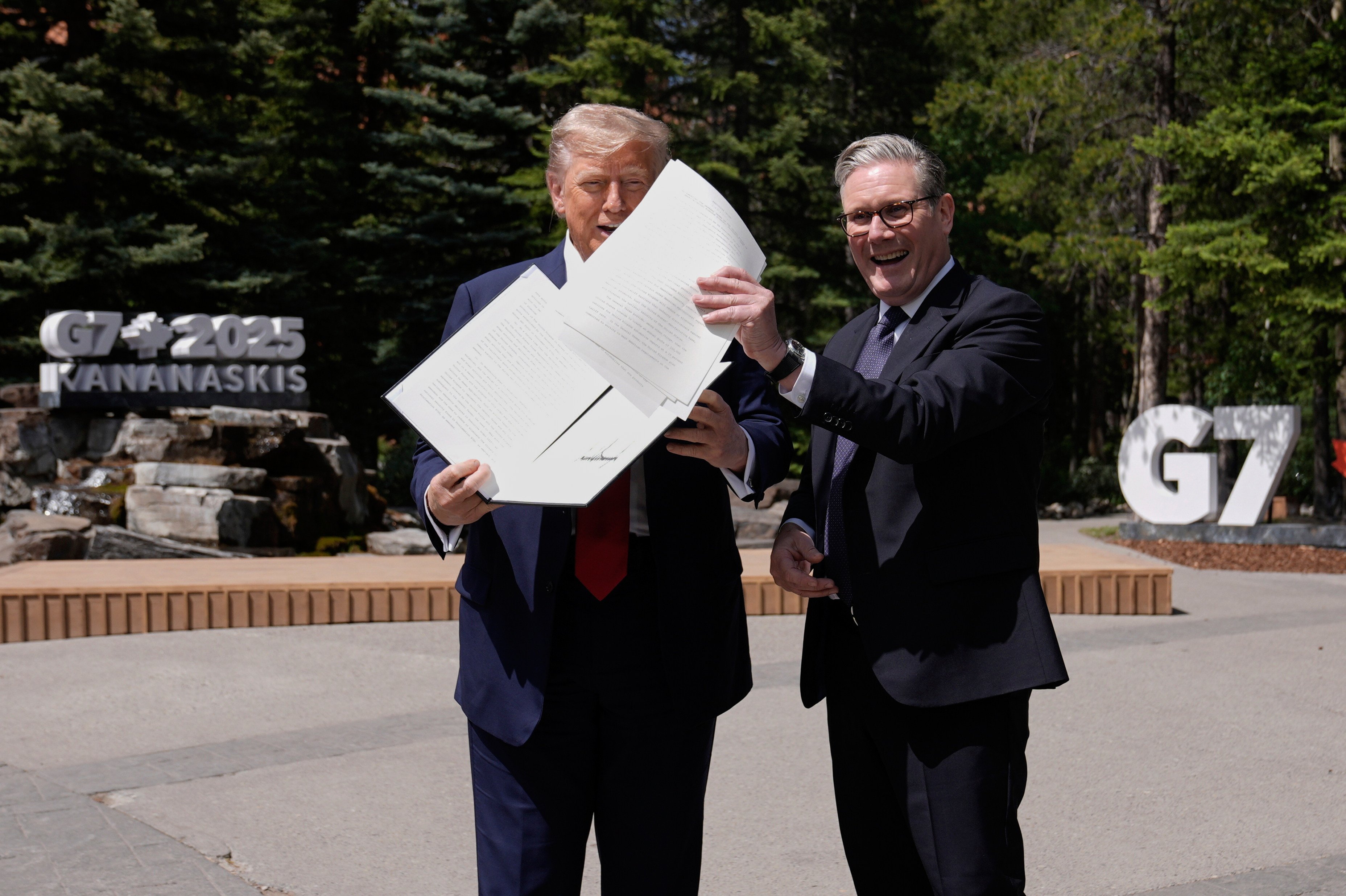 US President Donald Trump, left, holds a UK-US trade agreement with British Prime Minister Keir Starmer while speaking to the media at the G7 summit in Kananaskis, Canada, on Monday. Photo: Pool, via AP