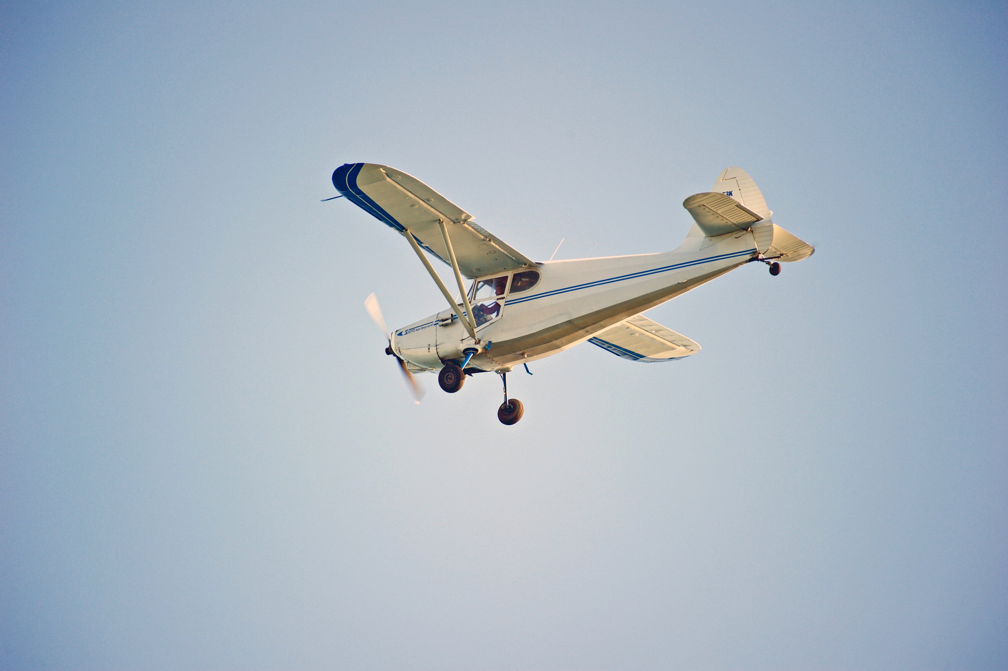 A Universal Stinson 108-2 flies over the Pacific Ocean in Huntington Beach, California, in October 2017. Photo: Shutterstock