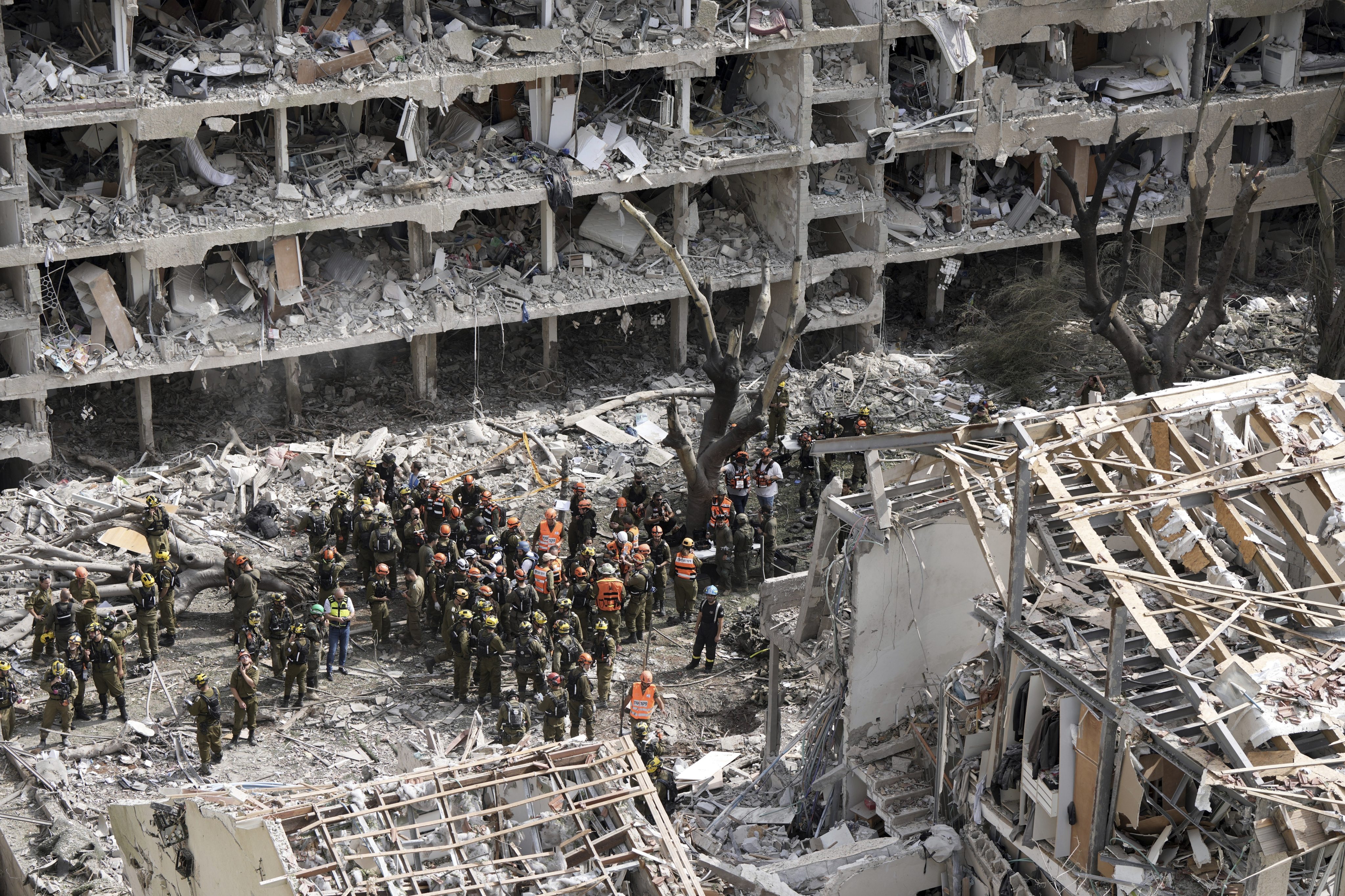 Israeli firefighters and rescuers gather at the site of a missile strike launched from Iran in Tel Aviv on Sunday. Photo: AP