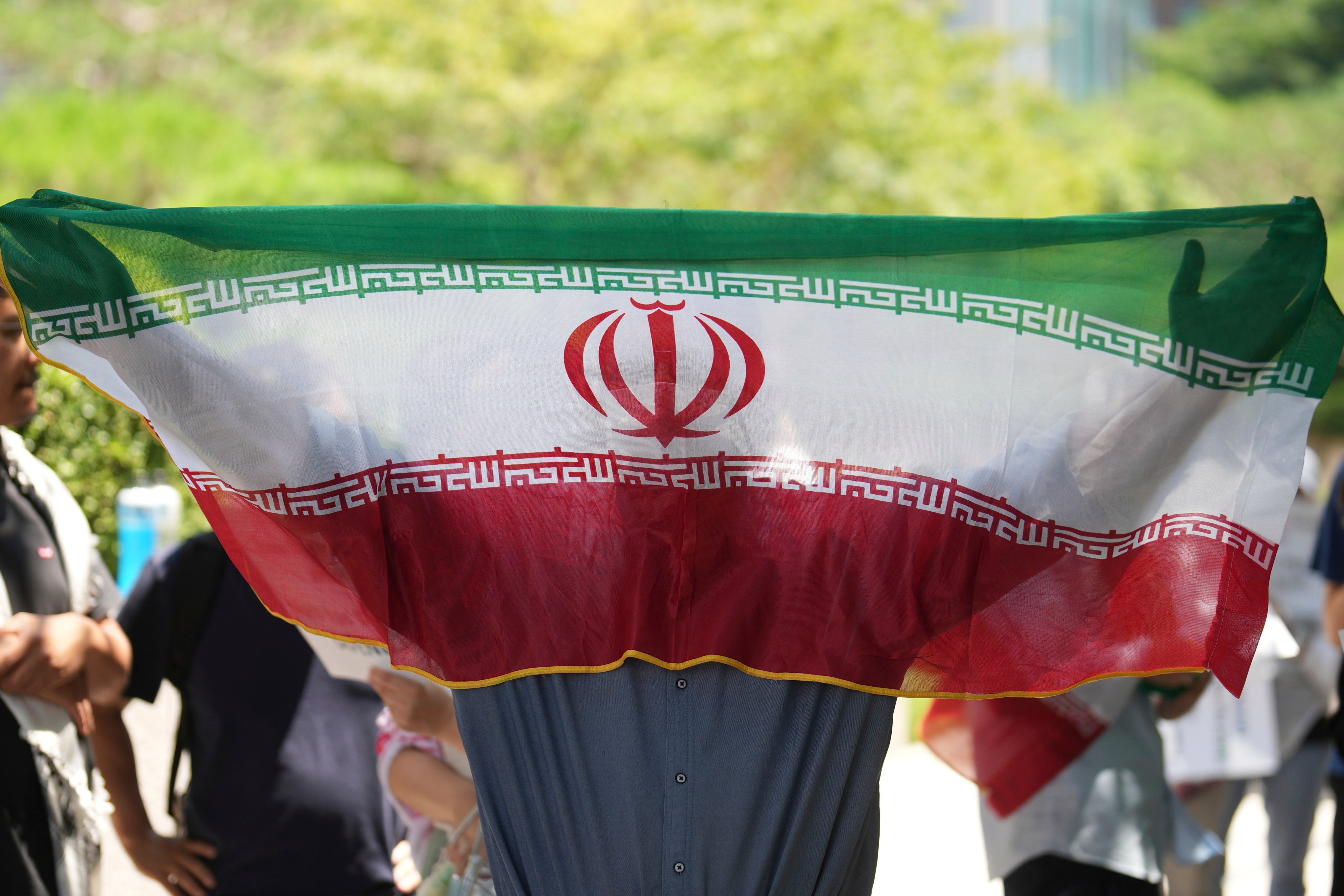 A man holds an Iranian flag during a rally demanding an end to the war between Israel and Iran in Seoul, South Korea on Sunday. Photo: AP