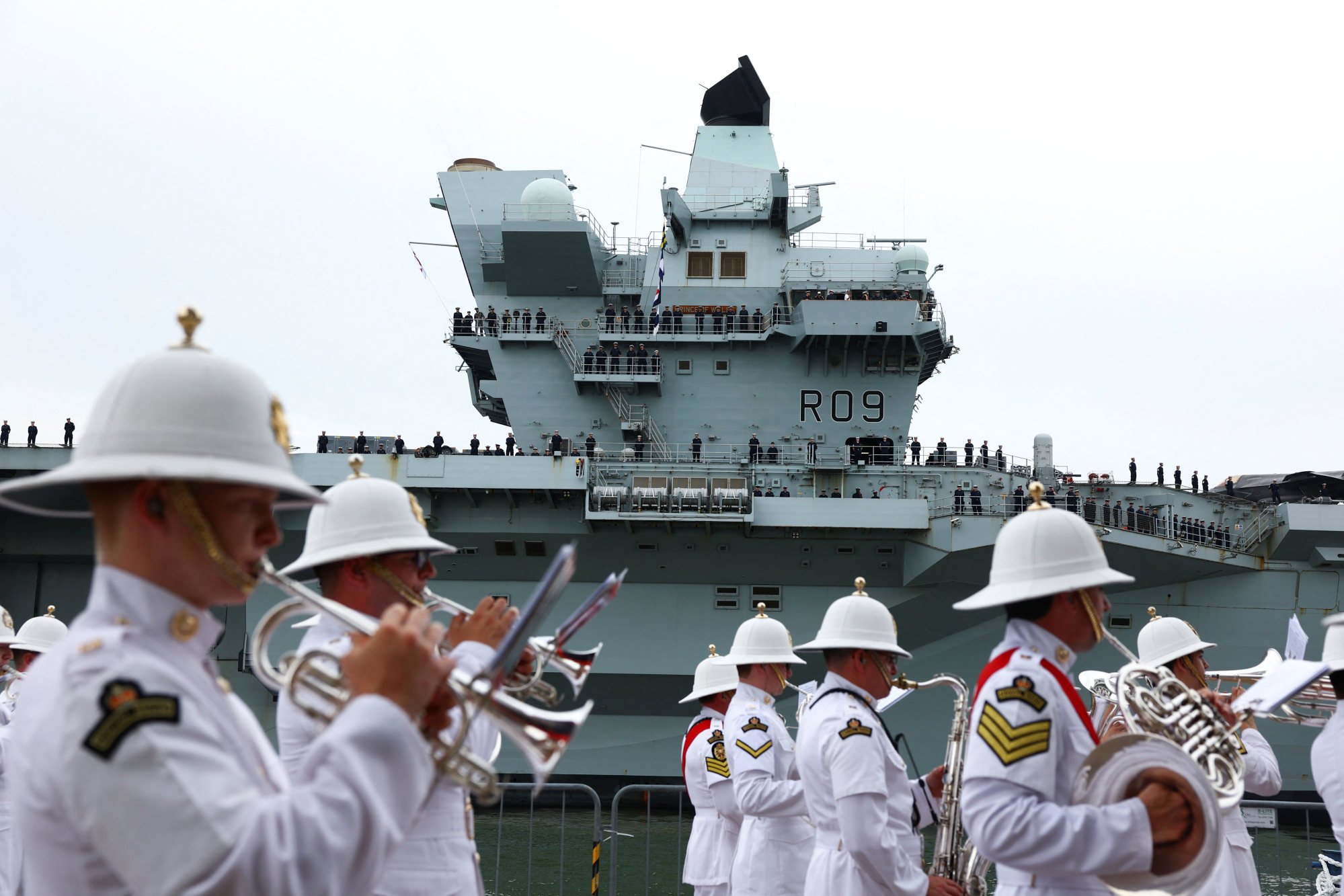 A military band performs as the HMS Prince of Wales aircraft carrier arrives in Singapore on Monday. The carrier will also take part in exercises with regional partners during an eight-month deployment. Photo: Reuters A military band performs as the HMS Prince of Wales aircraft carrier arrives in Singapore on Monday. The carrier will also take part in exercises with regional partners during an eight-month deployment. Photo: Reuters