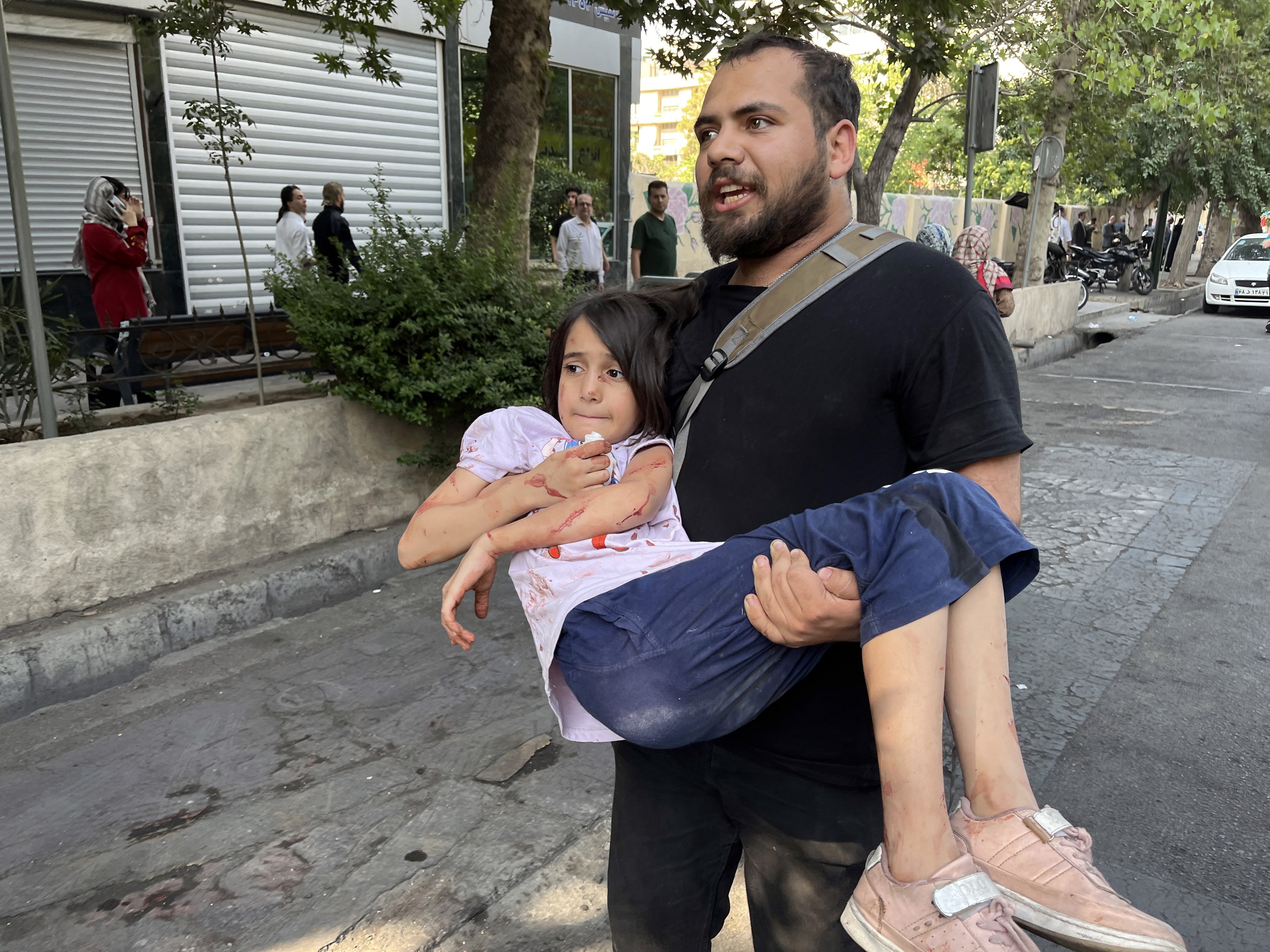 A man carries his wounded child following an Israeli airstrike on Tehran, Iran, on June 15. Photo: EPA-EFE