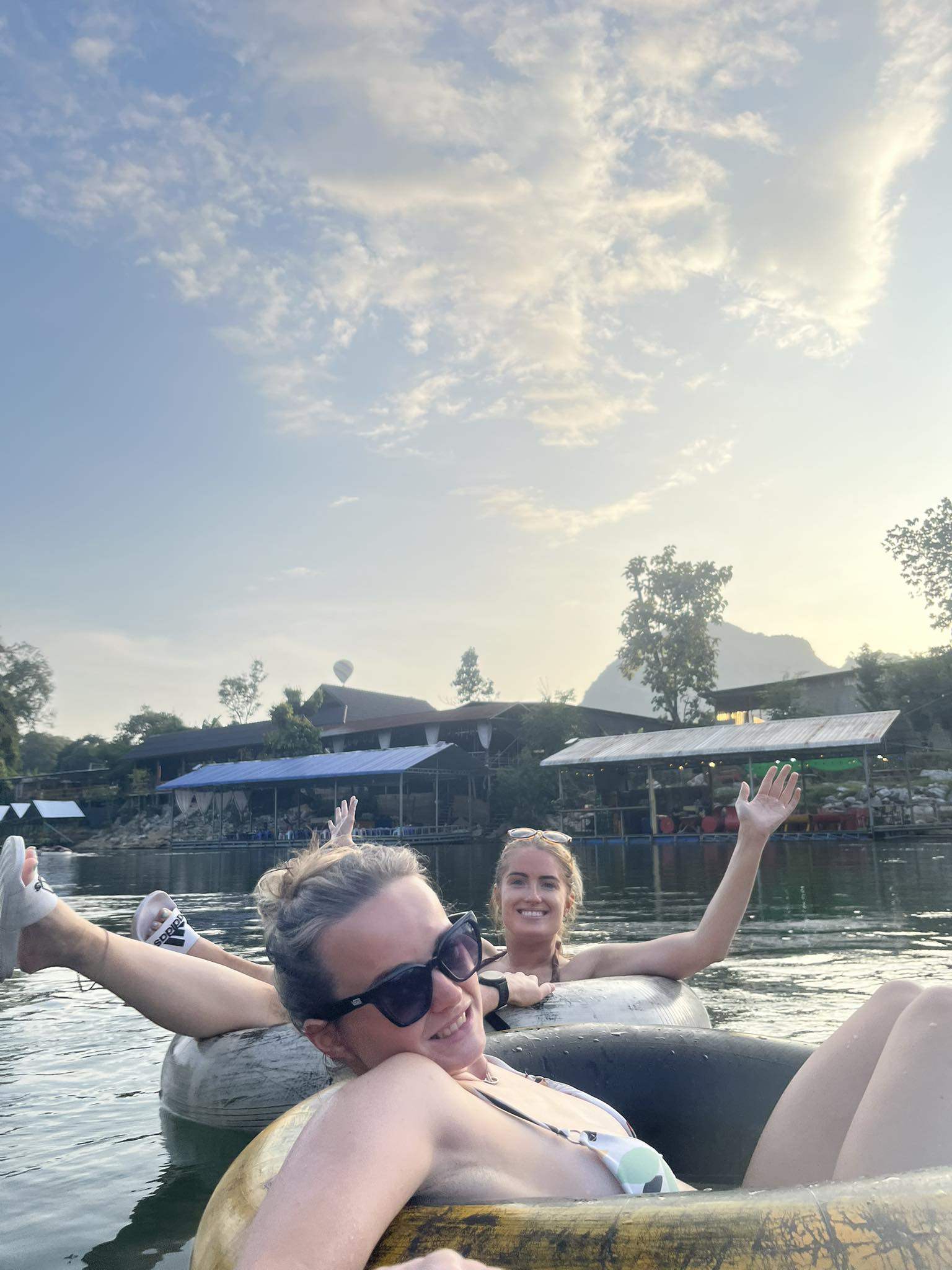 Simone White (back) and Bethany Clarke (front) tubing down a river in Laos on November 12, last year. Both would fall ill with methanol poisoning within 24 hours. Photo: Facebook/Bethany Clarke