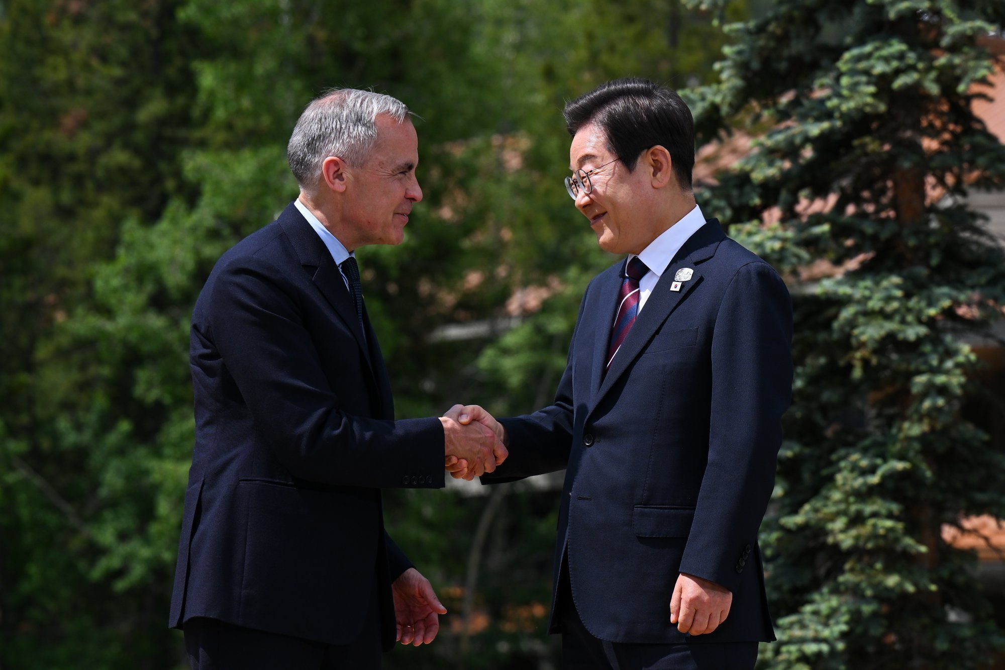 South Korean President Lee Jae-myung shakes hands with Canadian Prime Minister Mark Carney (left) at last week’s G7 summit. Trump left the G7 summit early amid escalating hostilities between Israel and Iran. Photo: EPA-EFE South Korean President Lee Jae-myung shakes hands with Canadian Prime Minister Mark Carney (left) at last week’s G7 summit. Trump left the G7 summit early amid escalating hostilities between Israel and Iran. Photo: EPA-EFE