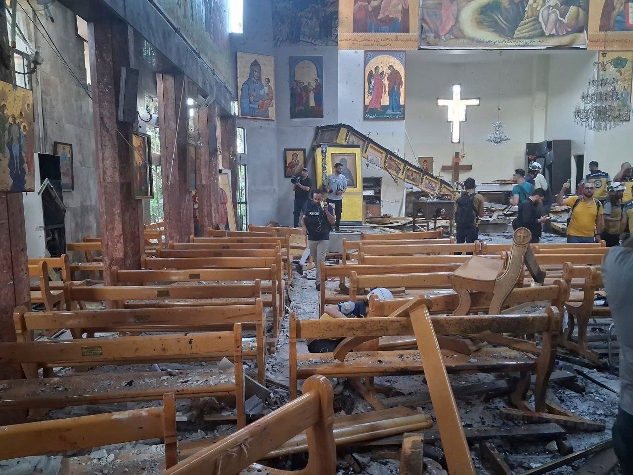 Journalists and civil defence workers inspect the damage inside Mar Elias church where a suicide bomber detonated himself in Dweil’a, on the outskirts of Damascus, Syria on Sunday. Photo: SANA via AP
