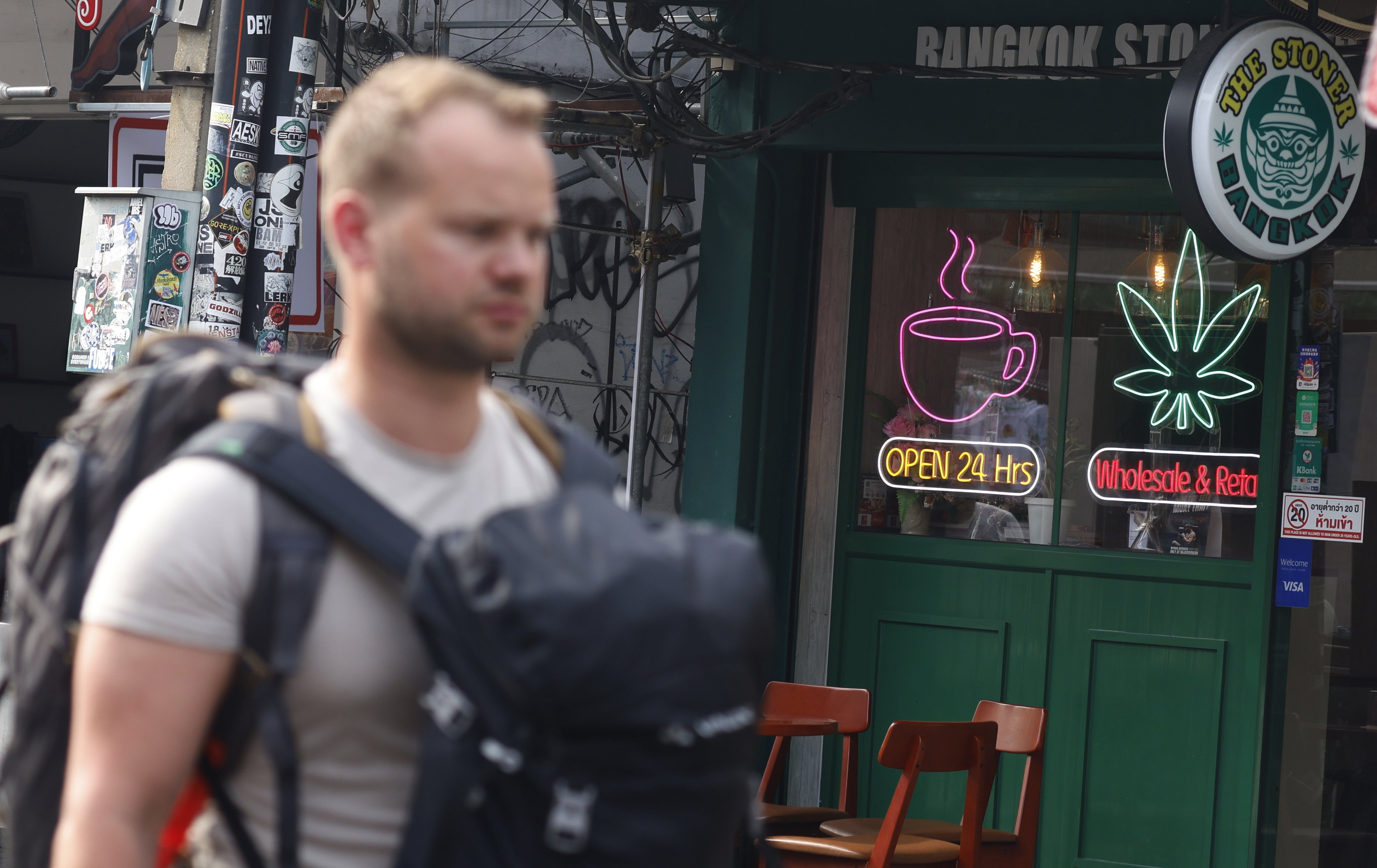 A tourist walks past a cannabis shop in the popular tourist area of Khaosan road in Bangkok. Photo: EPA-EFE