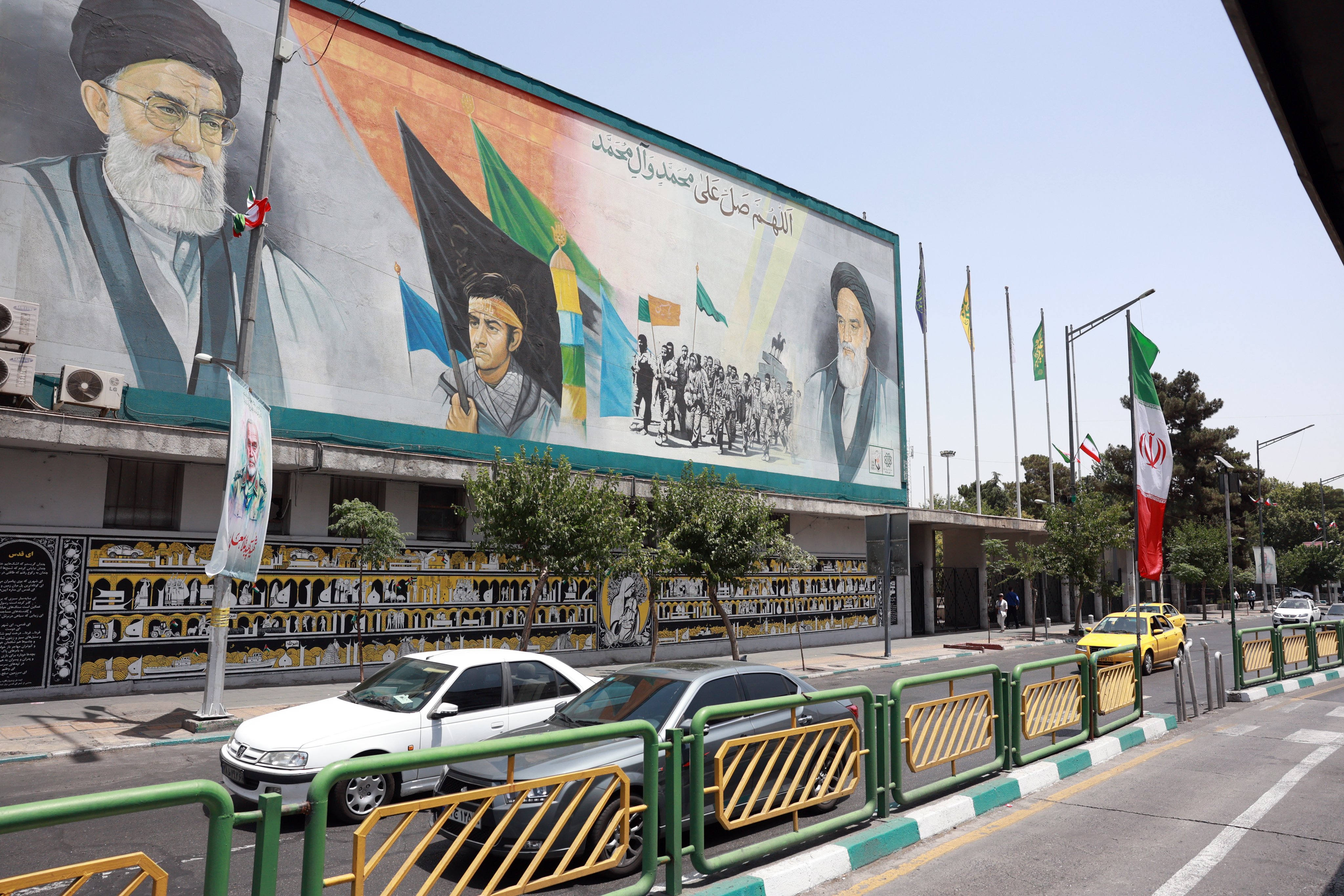 Vehicles drive past a mural showing Iran’s Supreme Leader Ayatollah Ali Khamenei (top left) and his predecessor, late supreme leader Ayatollah Ruhollah Khomeini, in Tehran on June 24. Photo: EPA-EFE