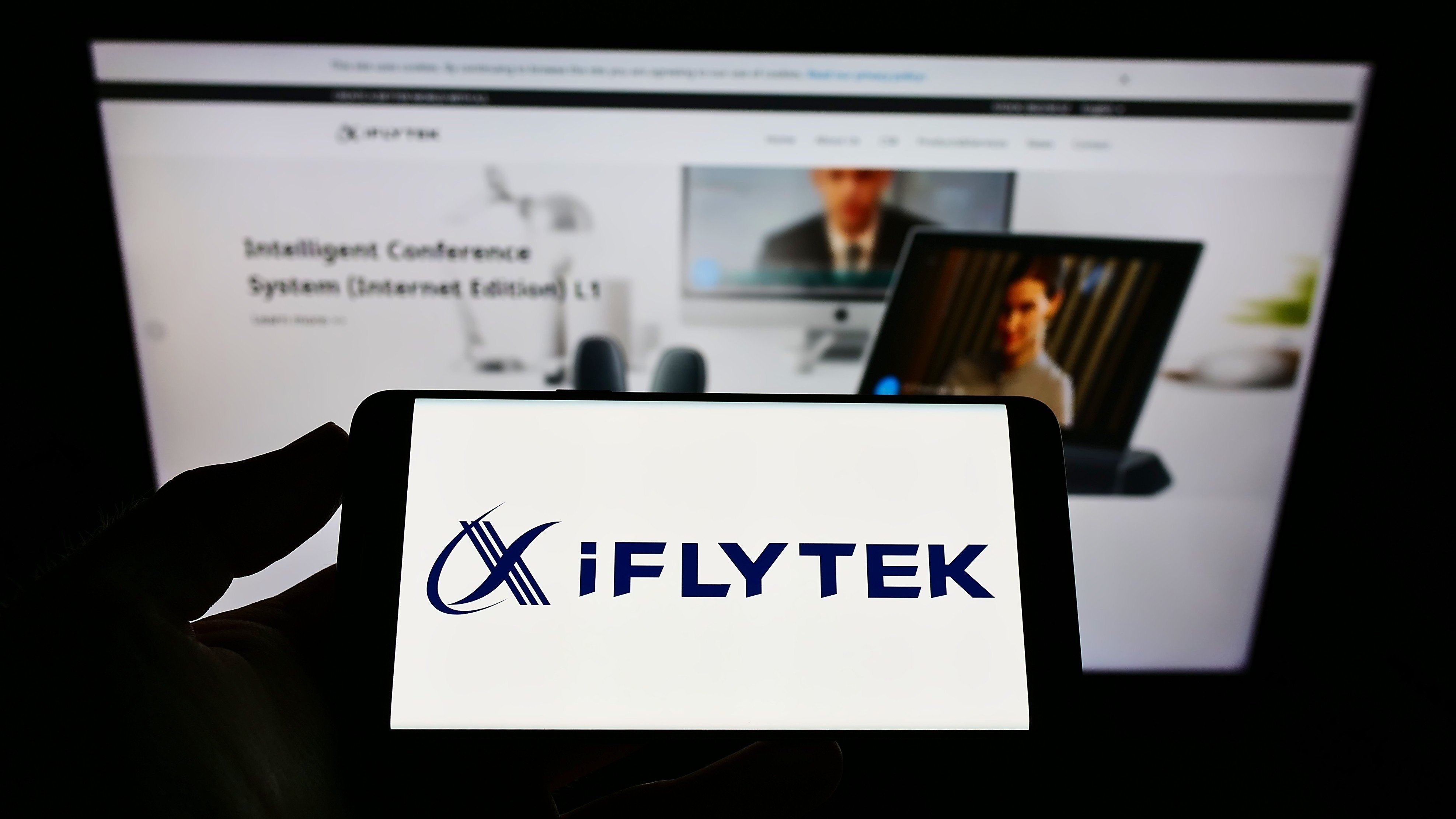 A smartphone displays the iFlytek logo in front of the company’s web page. Photo: Shutterstock Images