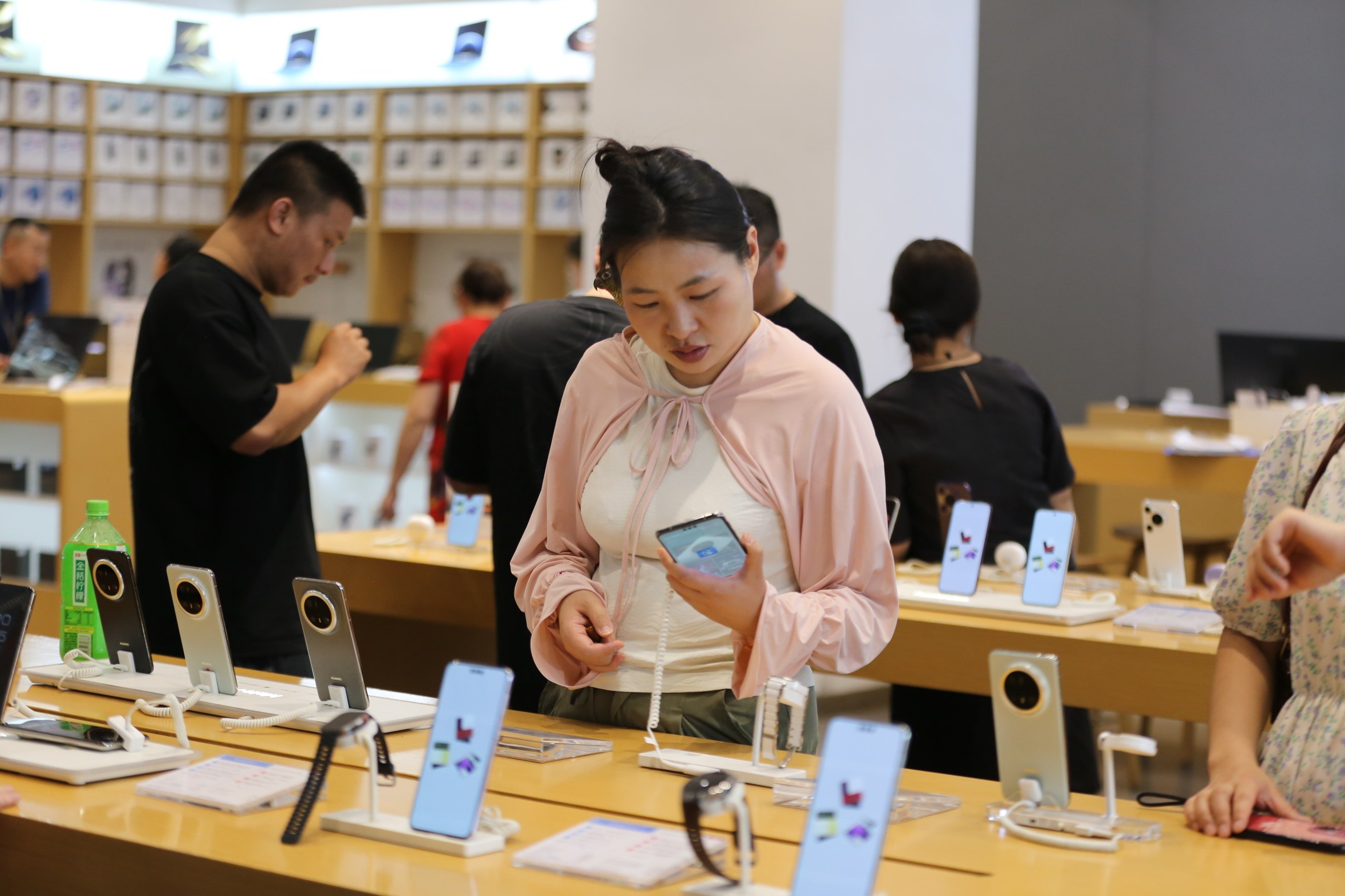 A customer checks out cellphones at a shop in Leshan, Sichuan province, on June 15. Photo: Xinhua