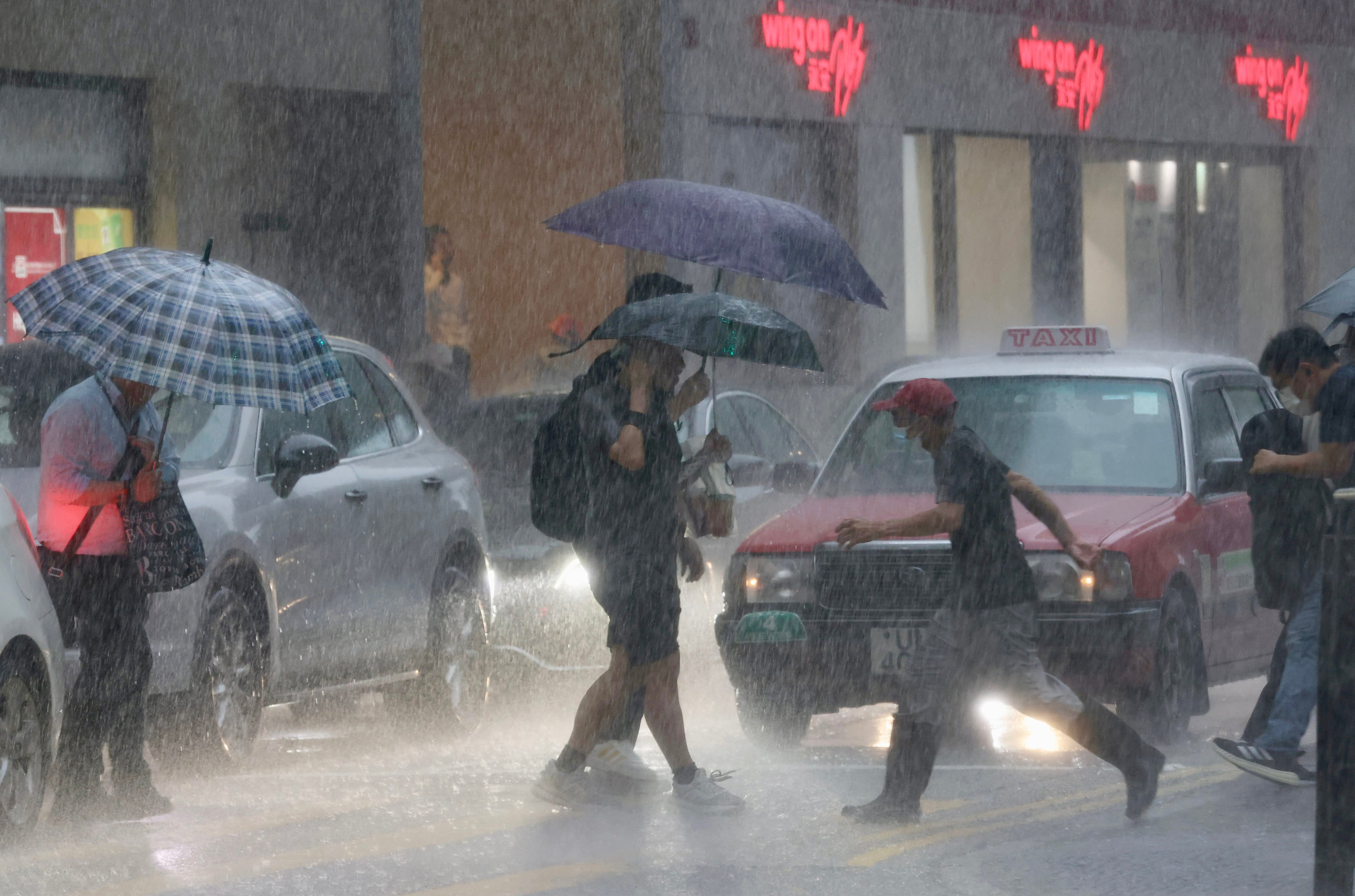 Pedestrians attempt to shelter from the rain in Sheung Wan. Photo: Jonathan Wong