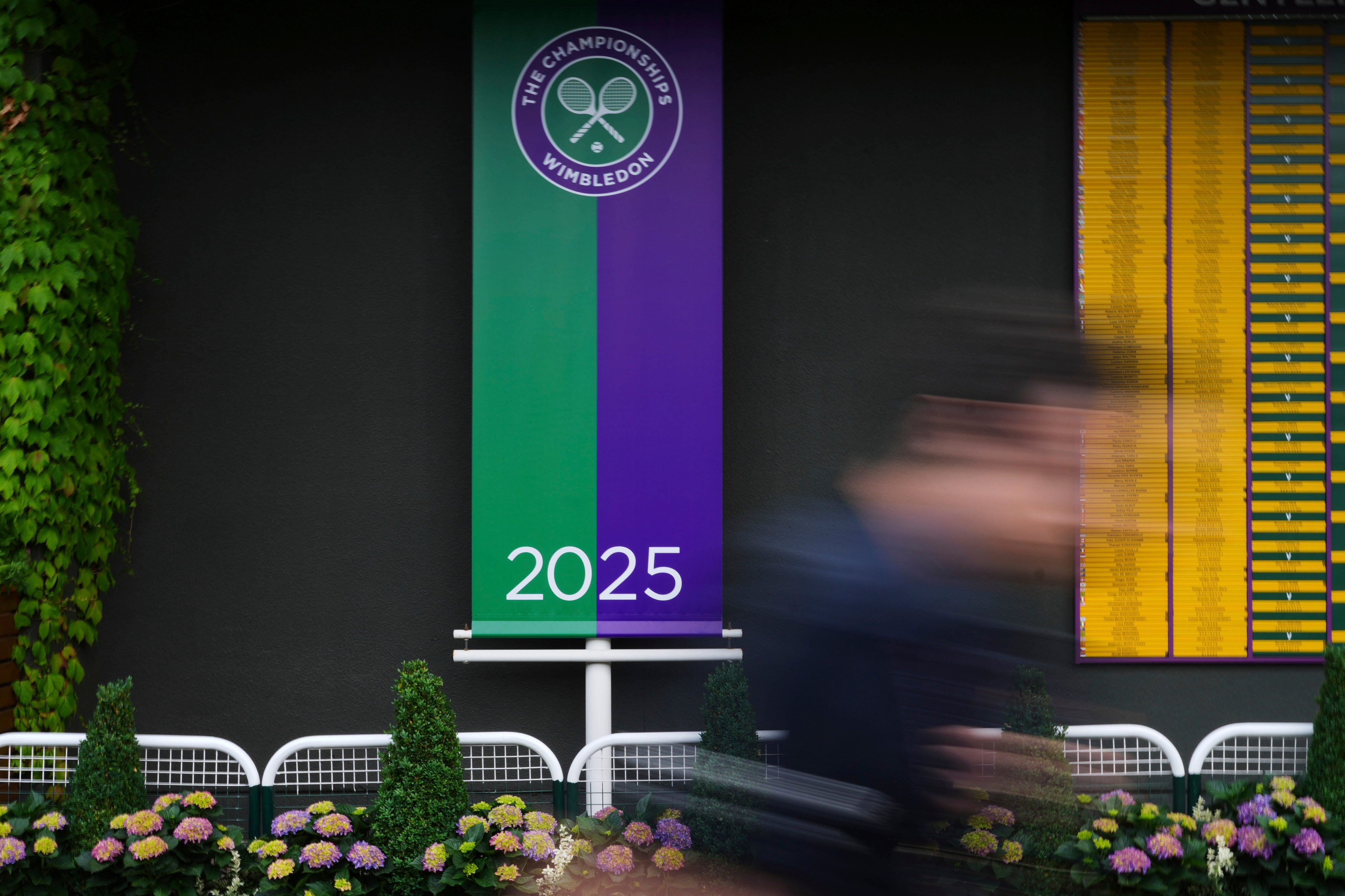A man walks past a sign for the 2025 championships at the All England Lawn Tennis and Croquet Club, ahead of the Wimbledon Championships in London, on Wednesday. Photo: AP