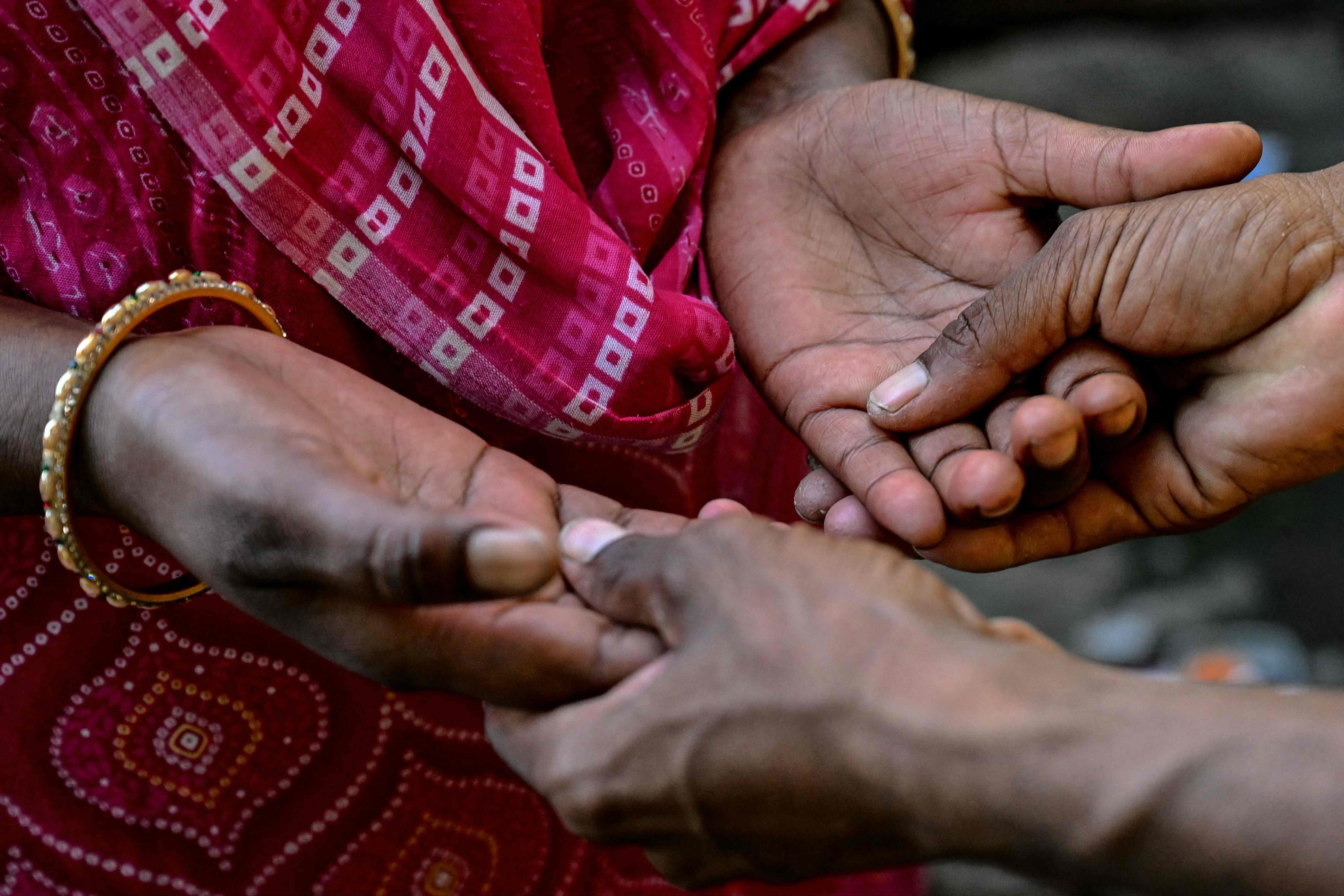 An Indian woman who was married as a child bride holds her husband’s hands at their home in Maharashtra state. Photo: AFP
