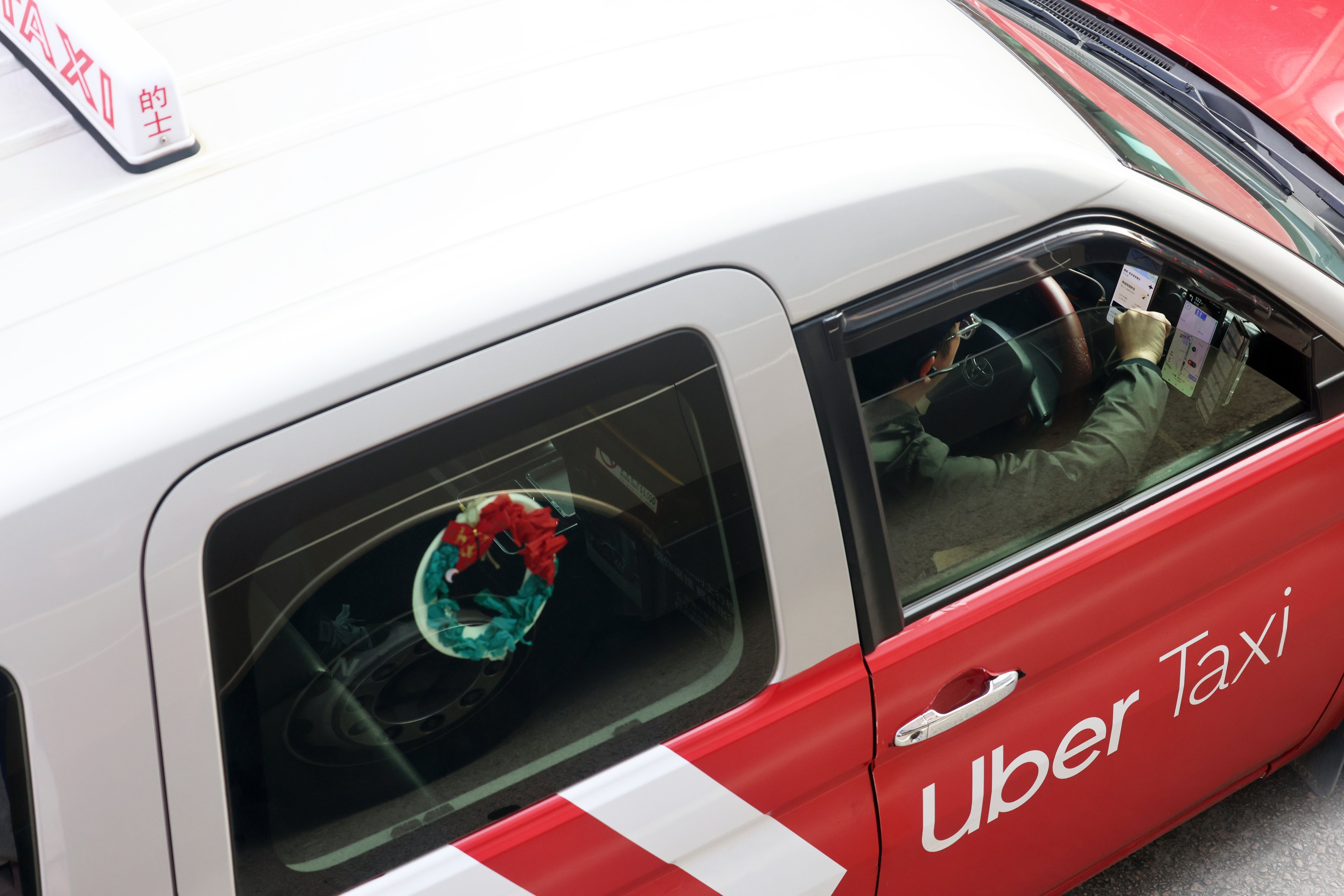 A taxi driver looks at a ride-hailing app on February 3. Photo: Jelly Tse