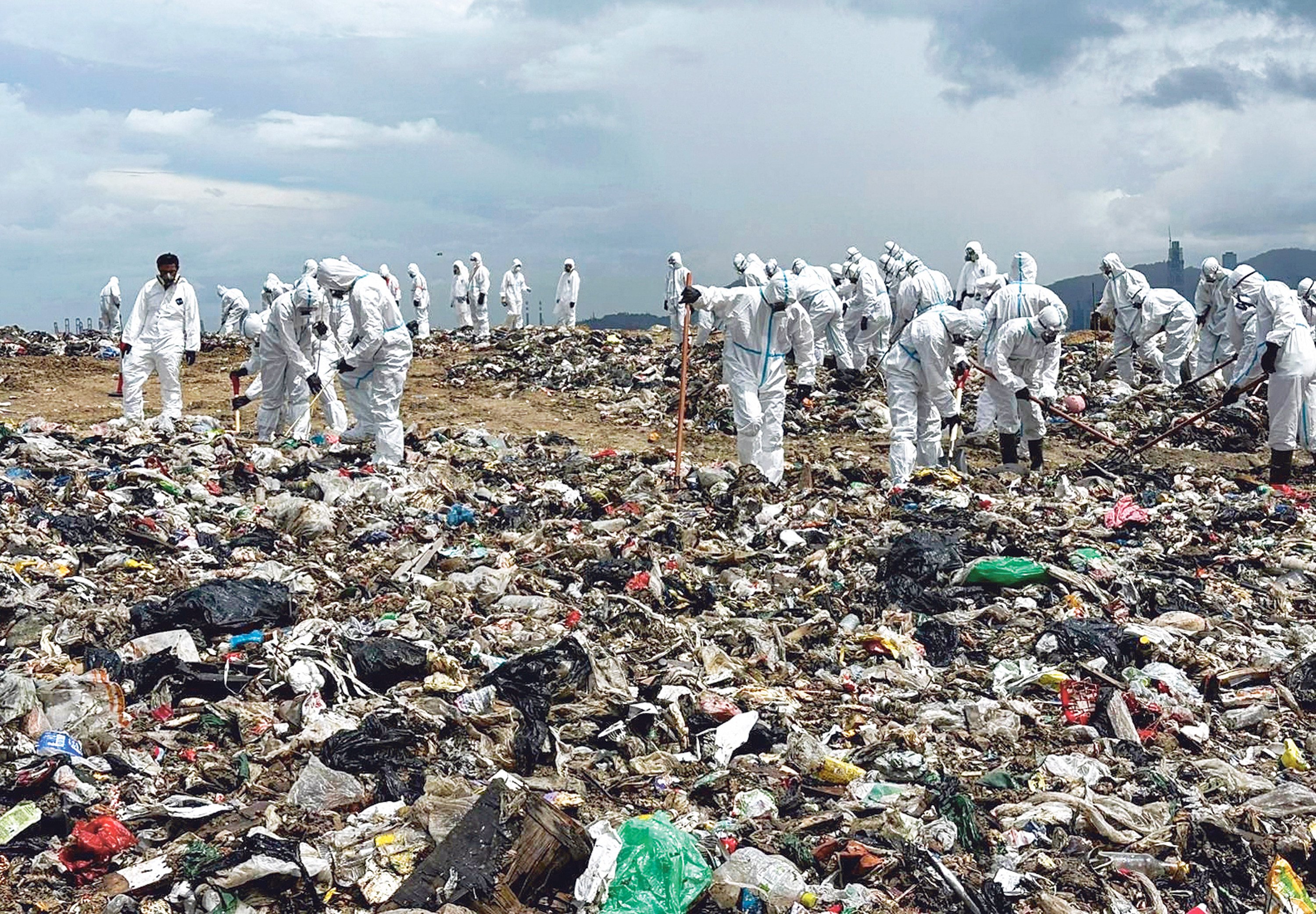 Police officers search a landfill in Tuen Mun for evidence in the case. Photo: Handout