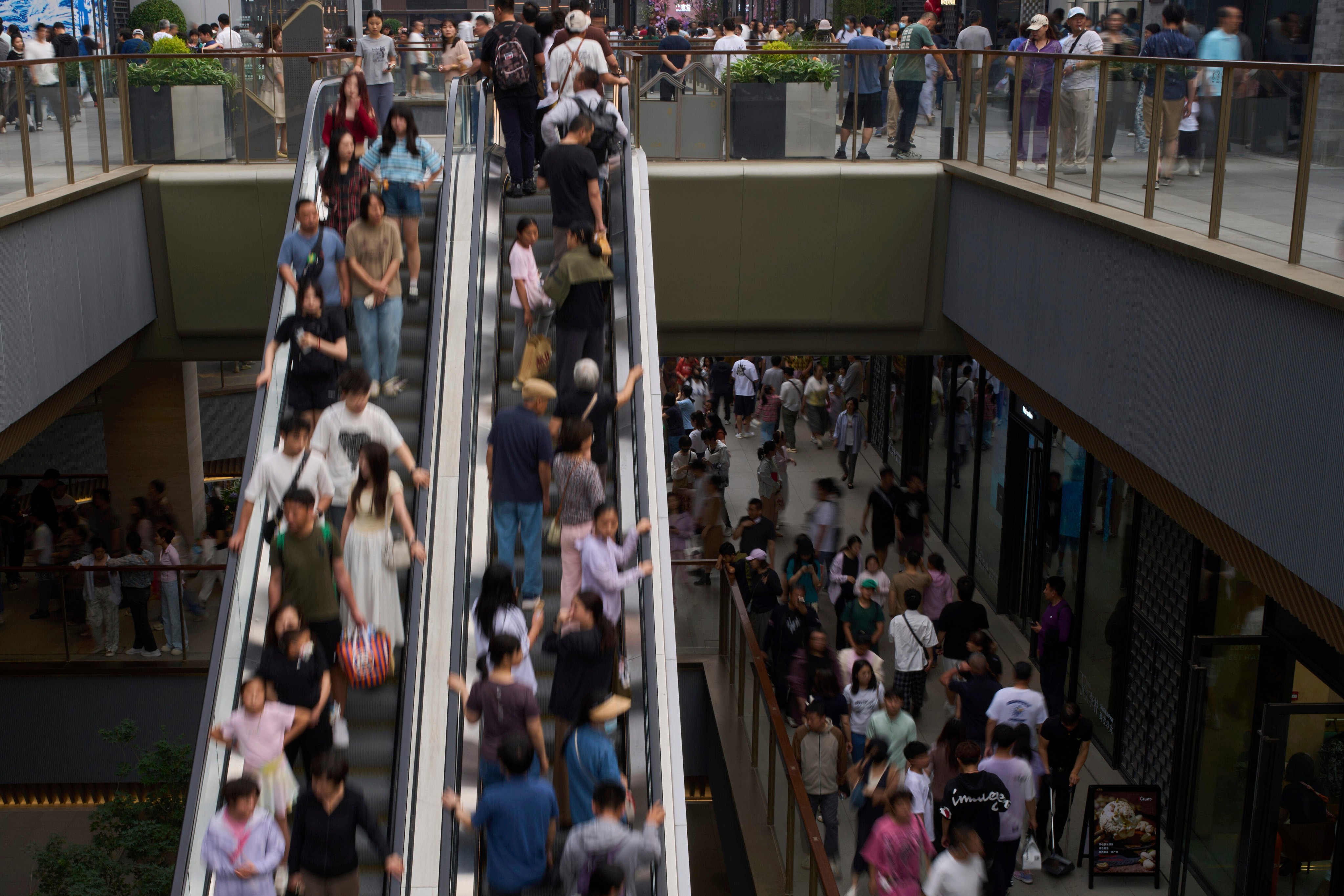 Shoppers visit a newly opened outdoor shopping mall in Beijing on June 1. Photo: AP