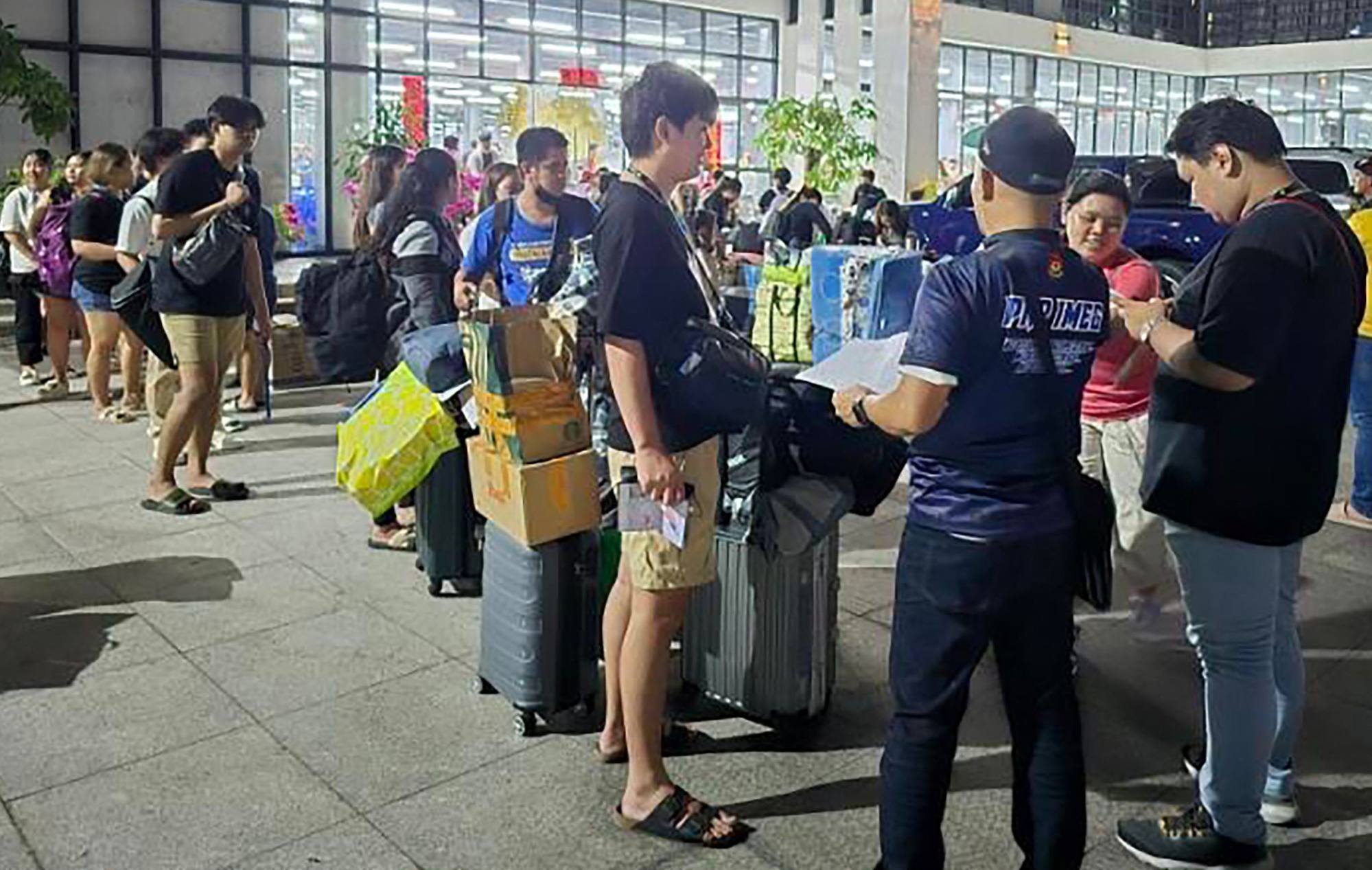 A police officer (front, centre) talking to foreign nationals after a raid in a scam centre within a complex of buildings in Bamban town of Tarlac province in March last year. Photo: PAOCC/AFP A police officer (front, centre) talking to foreign nationals after a raid in a scam centre within a complex of buildings in Bamban town of Tarlac province in March last year. Photo: PAOCC/AFP