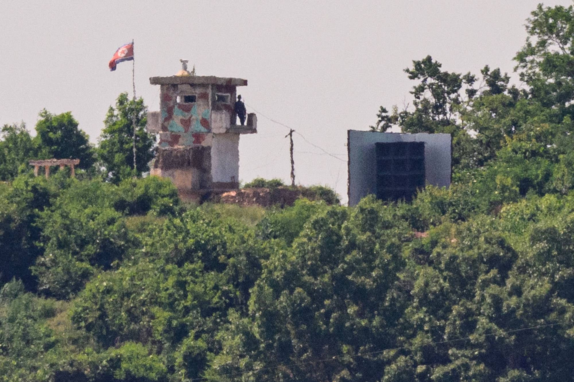 A North Korean soldier stands guard in a watchtower next to a giant loudspeaker (right) near the demilitarised zone dividing the two Koreas on June 12. Photo: AFP A North Korean soldier stands guard in a watchtower next to a giant loudspeaker (right) near the demilitarised zone dividing the two Koreas on June 12. Photo: AFP