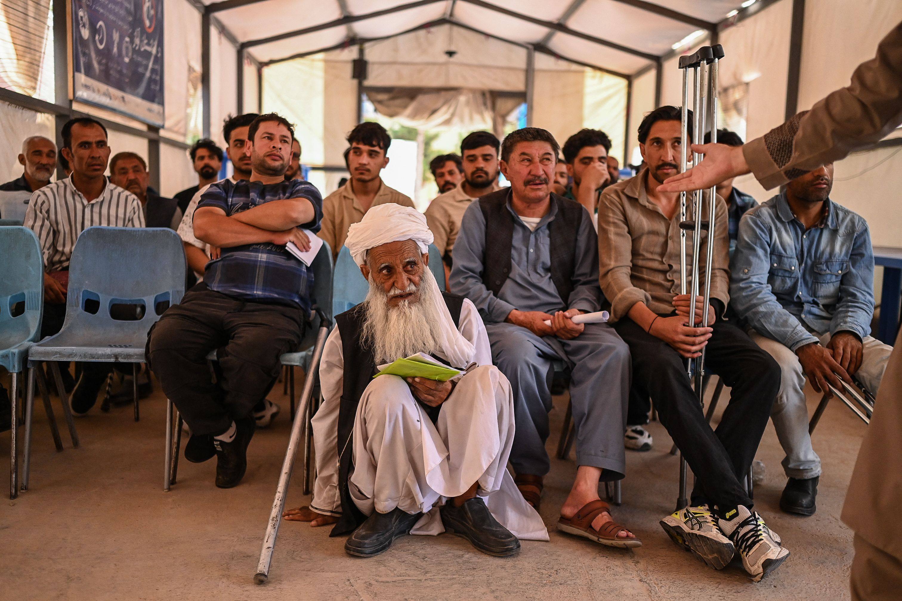 Afghan refugees, who were deported from Iran, wait at a registration centre of the International Organisation for Migration (IOM) in Herat, Afghanisation, on Saturday. Photo: AFP