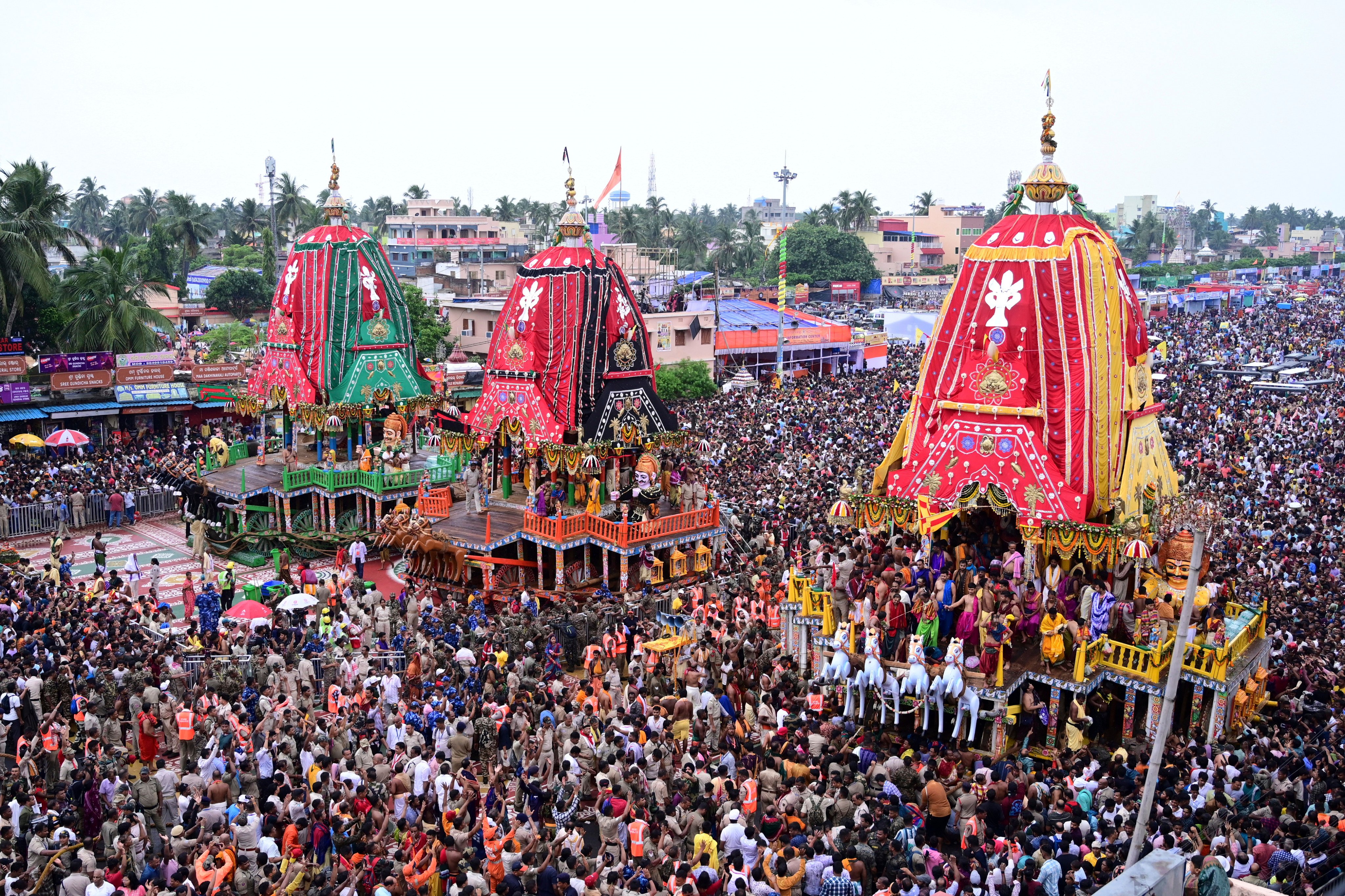 Hindu devotees walk in a procession accompanying three large chariots housing deities, in Puri, India, on Saturday. Photo: AP