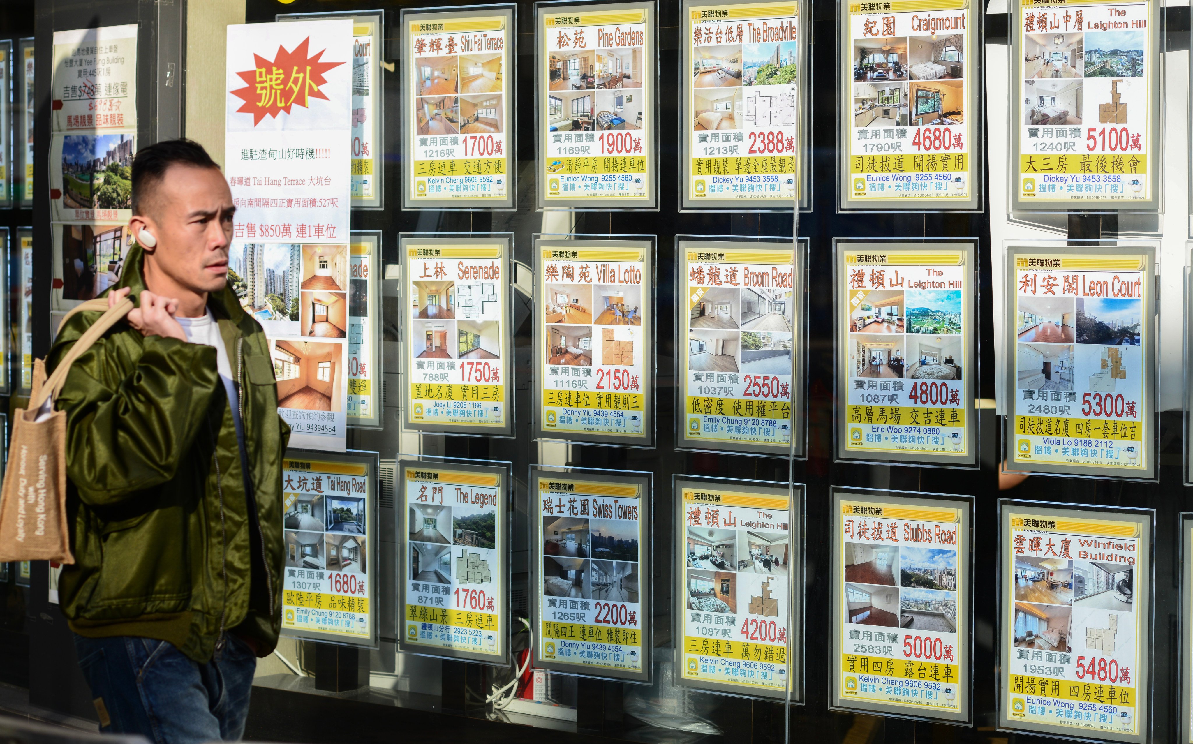 A man passes a real estate office in Causeway Bay. Photo: Antony Dickson