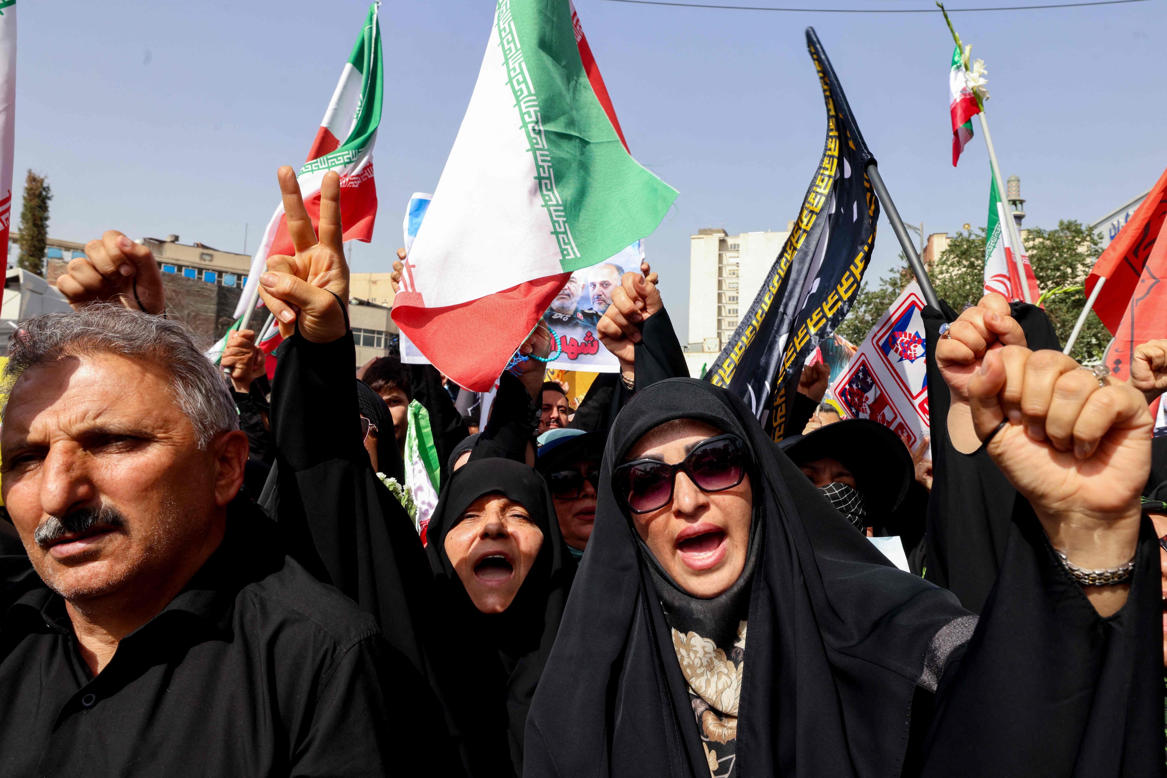 Mourners wave flags and chant slogans during a funeral procession in Tehran on Saturday for Iranian military commanders and scientists killed during Israeli strikes. Photo: AFP