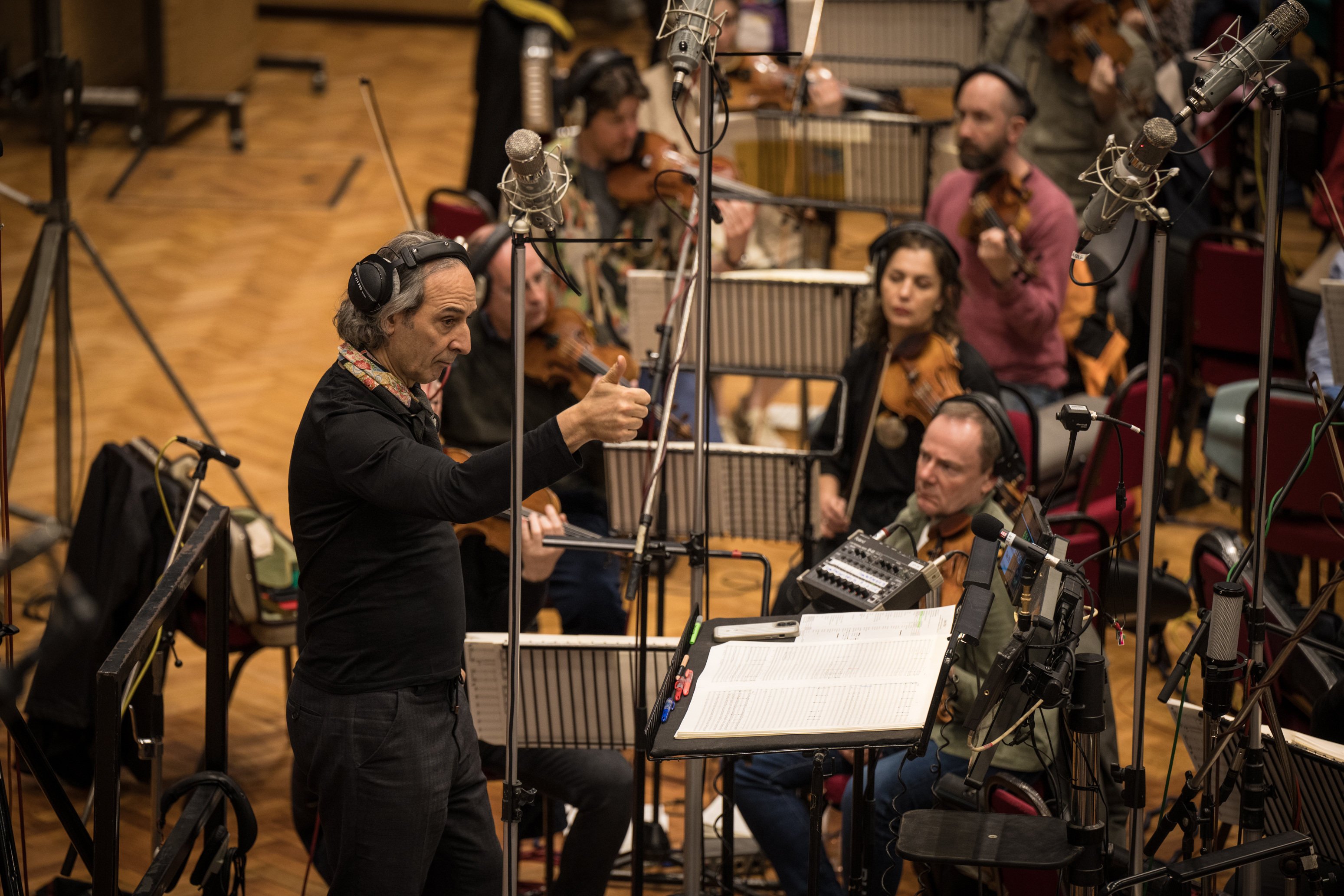 Composer Alexandre Desplat gives a thumbs up while conducting the music for the new Jurassic World film at a recording session at London’s Abbey Road Studios. Photo: Lara Cornell/Universal Pictures