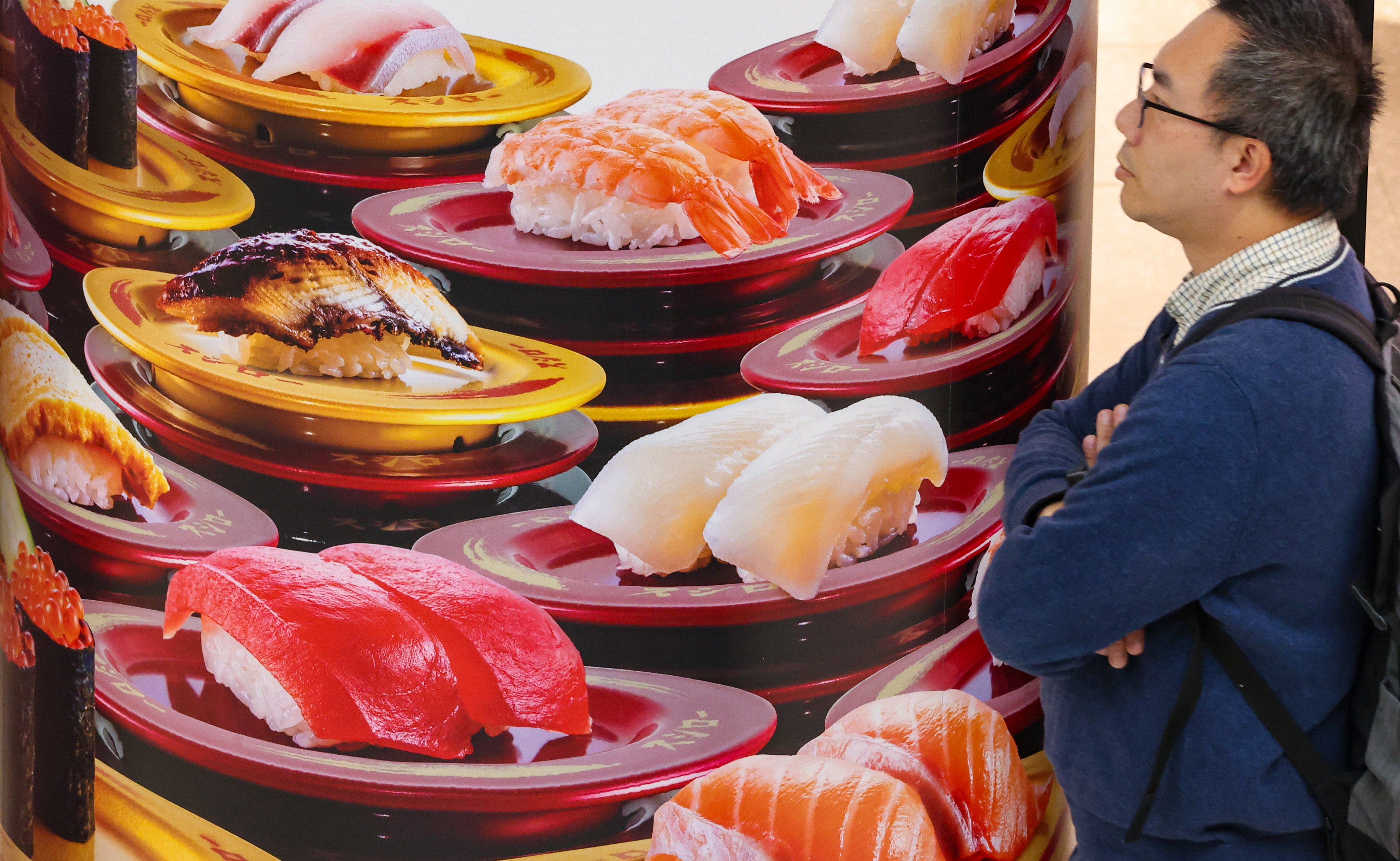 A customer looks at an advertisement of a Japanese restaurant in a Mong Kok shopping mall. Photo: Jelly Tse