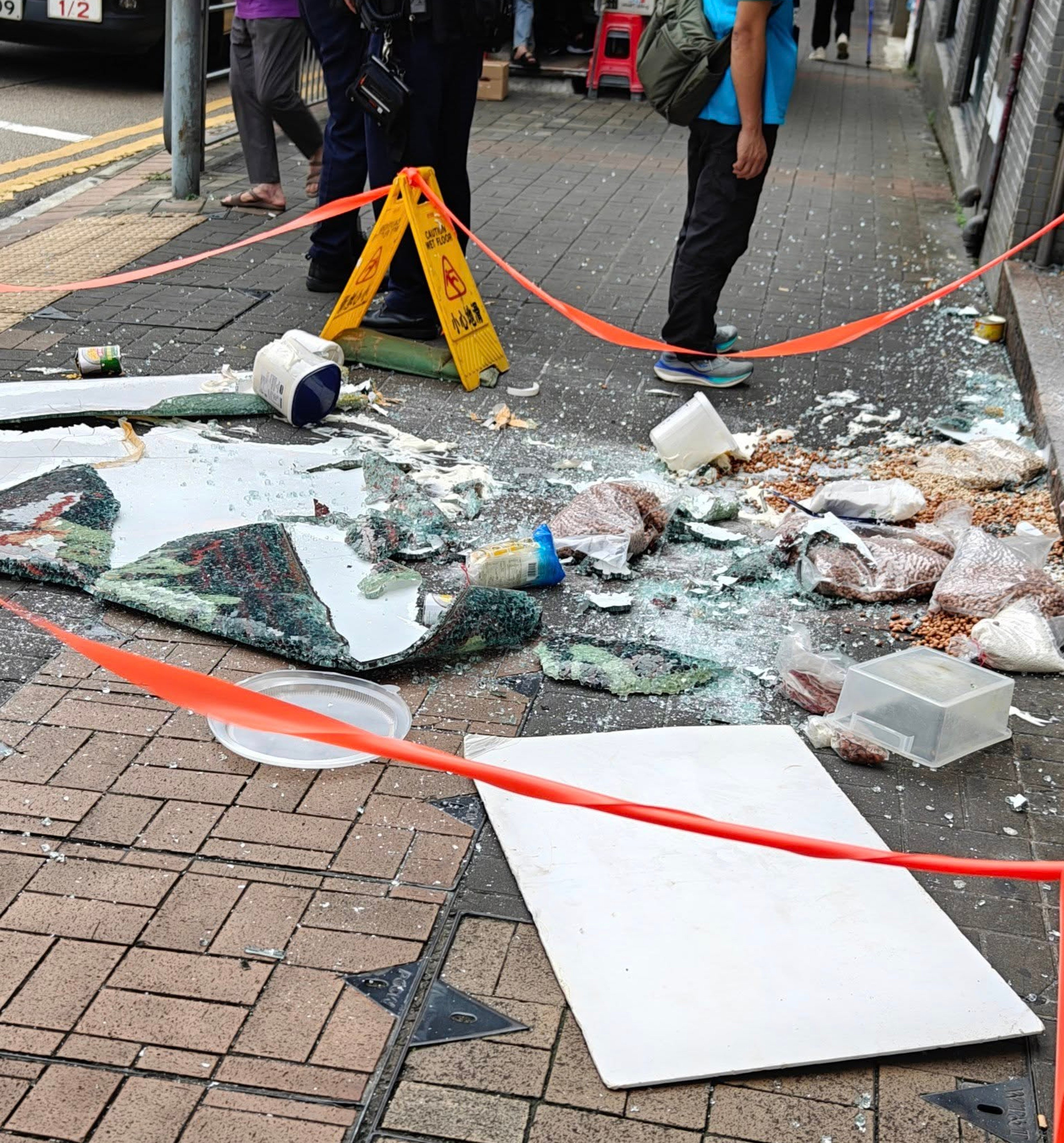Shattered glass and food items fell onto the street from the first-floor Cafe de Coral branch. Photo: SCMP