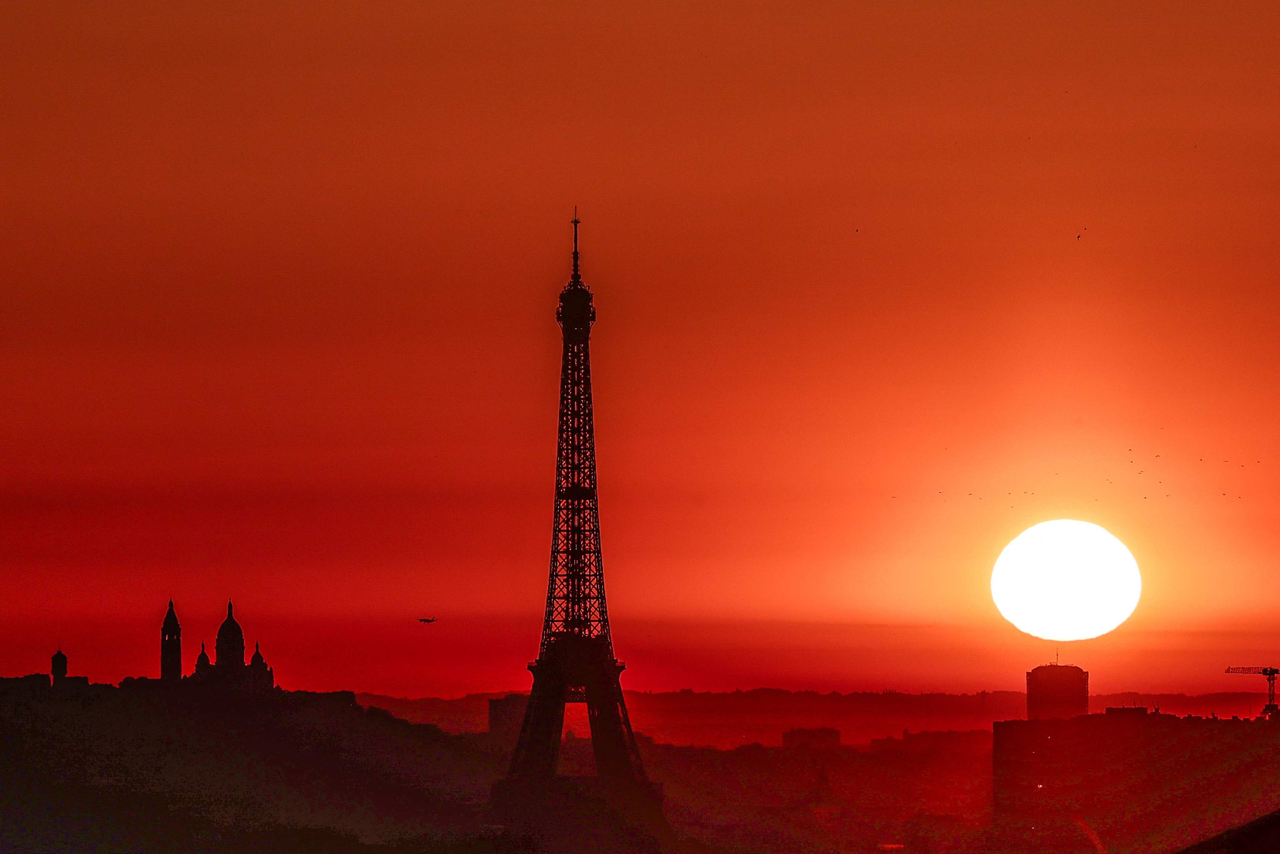 The sun rises by the Eiffel Tower in Paris on Tuesday. Photo: AFP