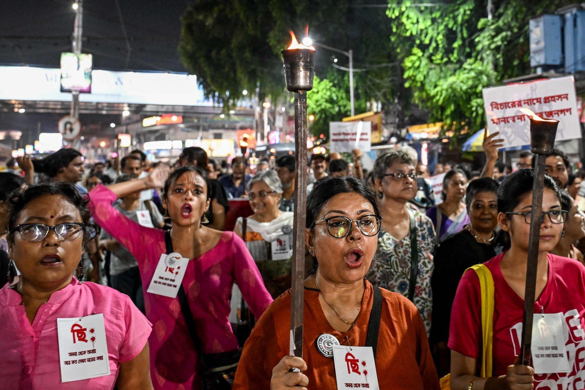 Social activists carrying torches shout slogans as they protest against the alleged gang rape of a student inside a law college, during a rally in Kolkata on Sunday. Photo: AFP