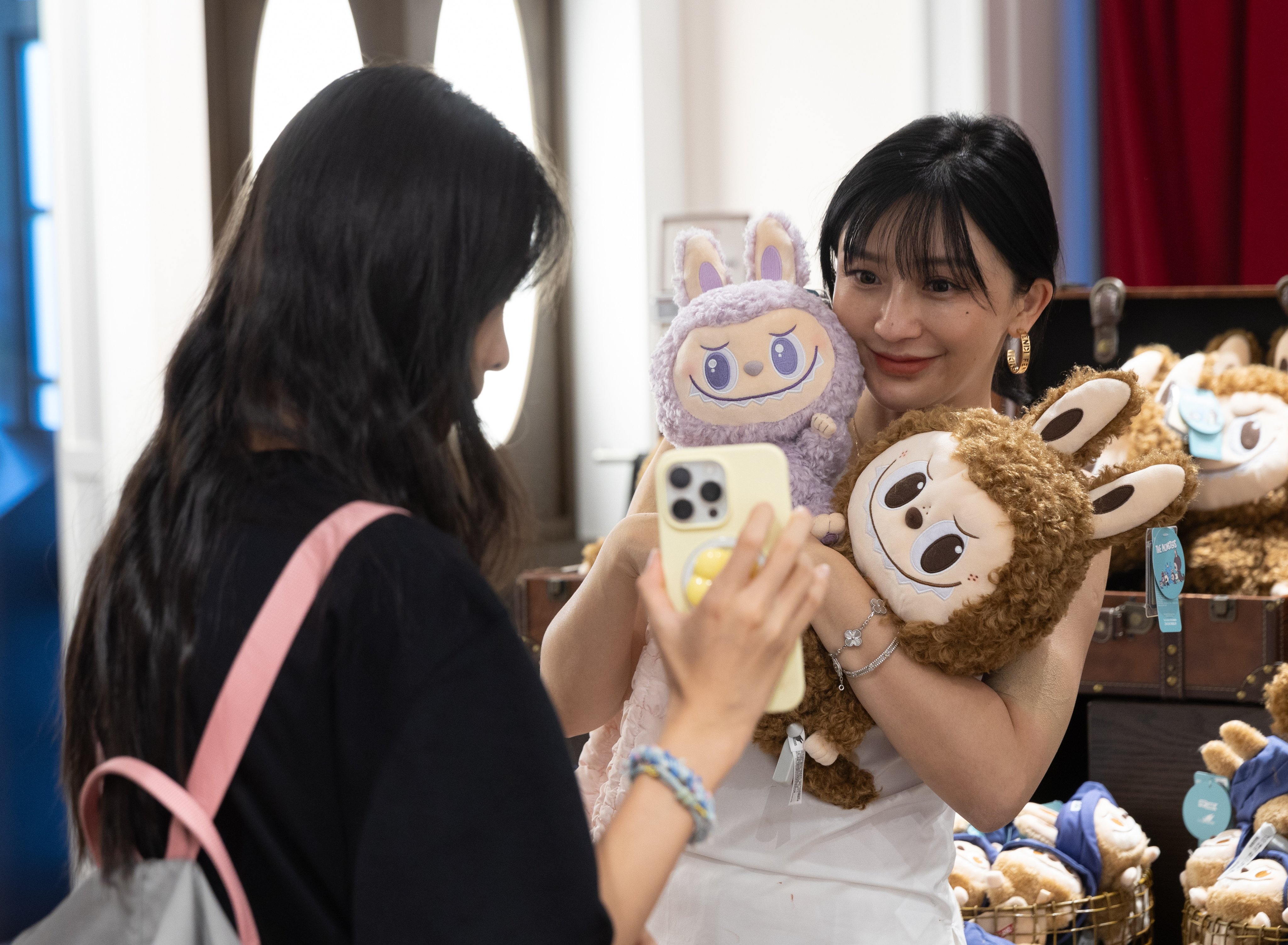 A person holds up Labubu dolls in a store during a press tour to Pop Land, a theme park opened by Chinese toy company Pop Mart, in Beijing, China, on June 2. Photo: EPA-EFE