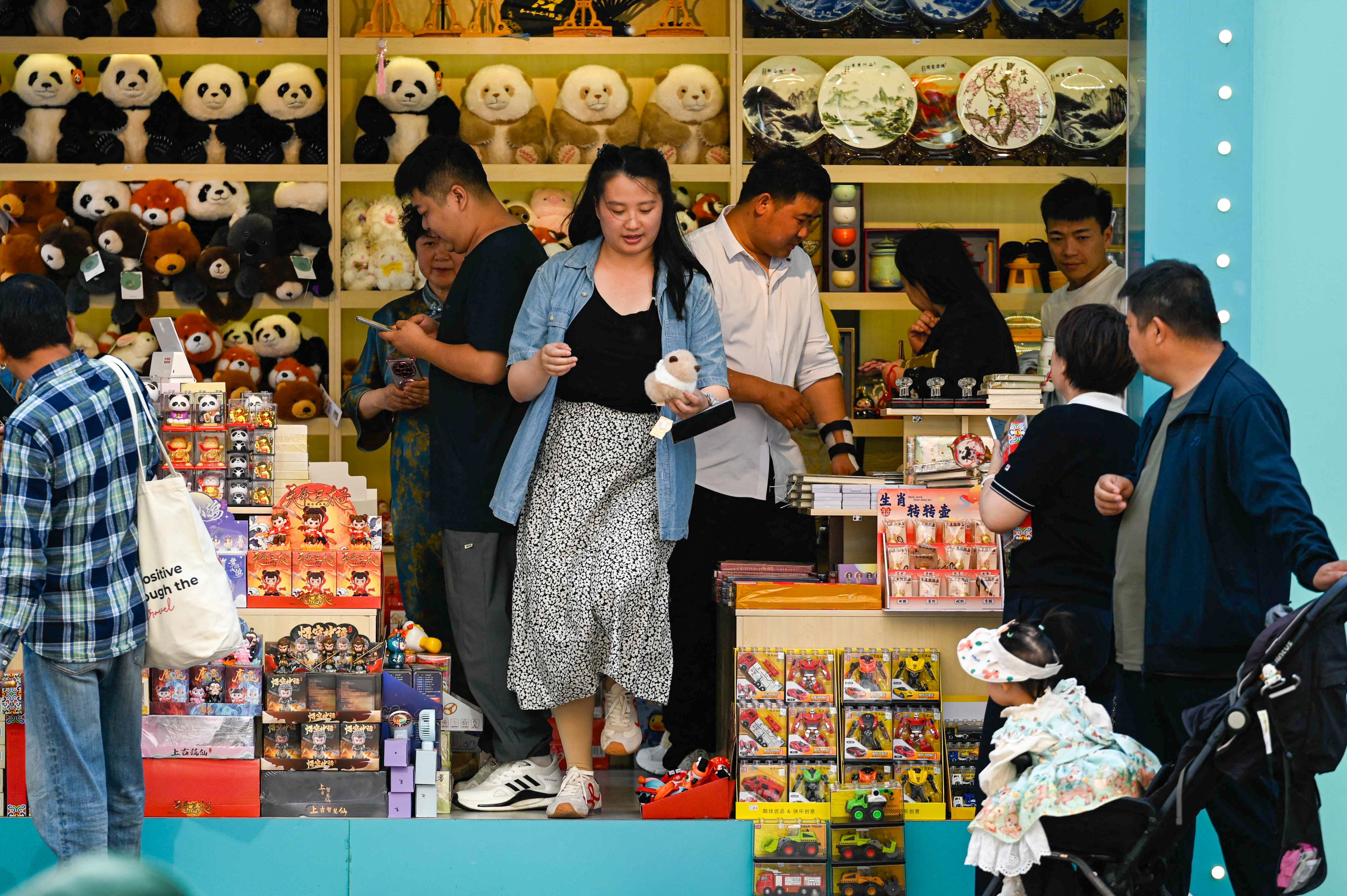 People shop along a business street in Beijing. Some analysts say China’s consumption levels are better than many people believe. Photo: AFP