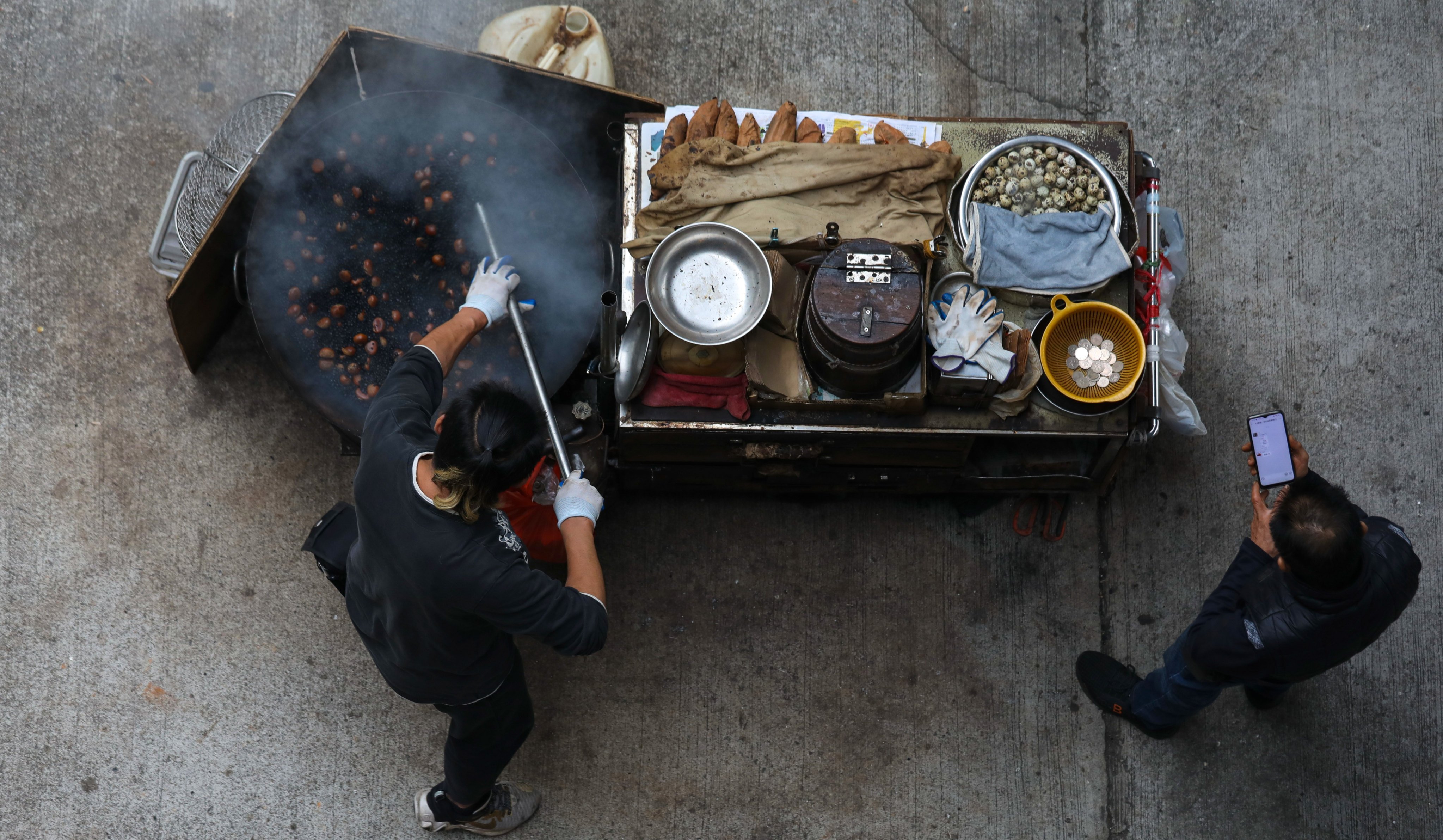 A hawker roasts chestnuts on his food cart in Tuen Mun. Photo: Xiaomei Chen