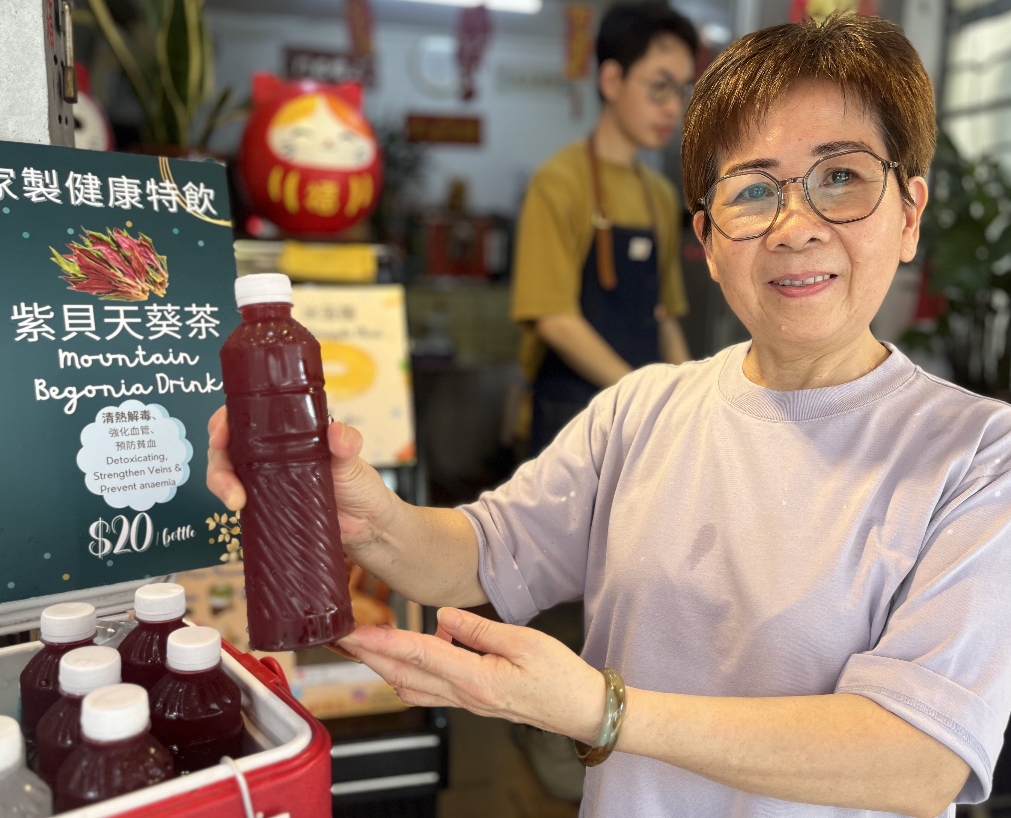 Lily Wong holds a bottle of her homemade mountain begonia drink that she sells in Tai O, a historic fishing village in Hong Kong. Locals and a TCM expert share the benefits and risks of the ingredient. Photo: Kylie Knott