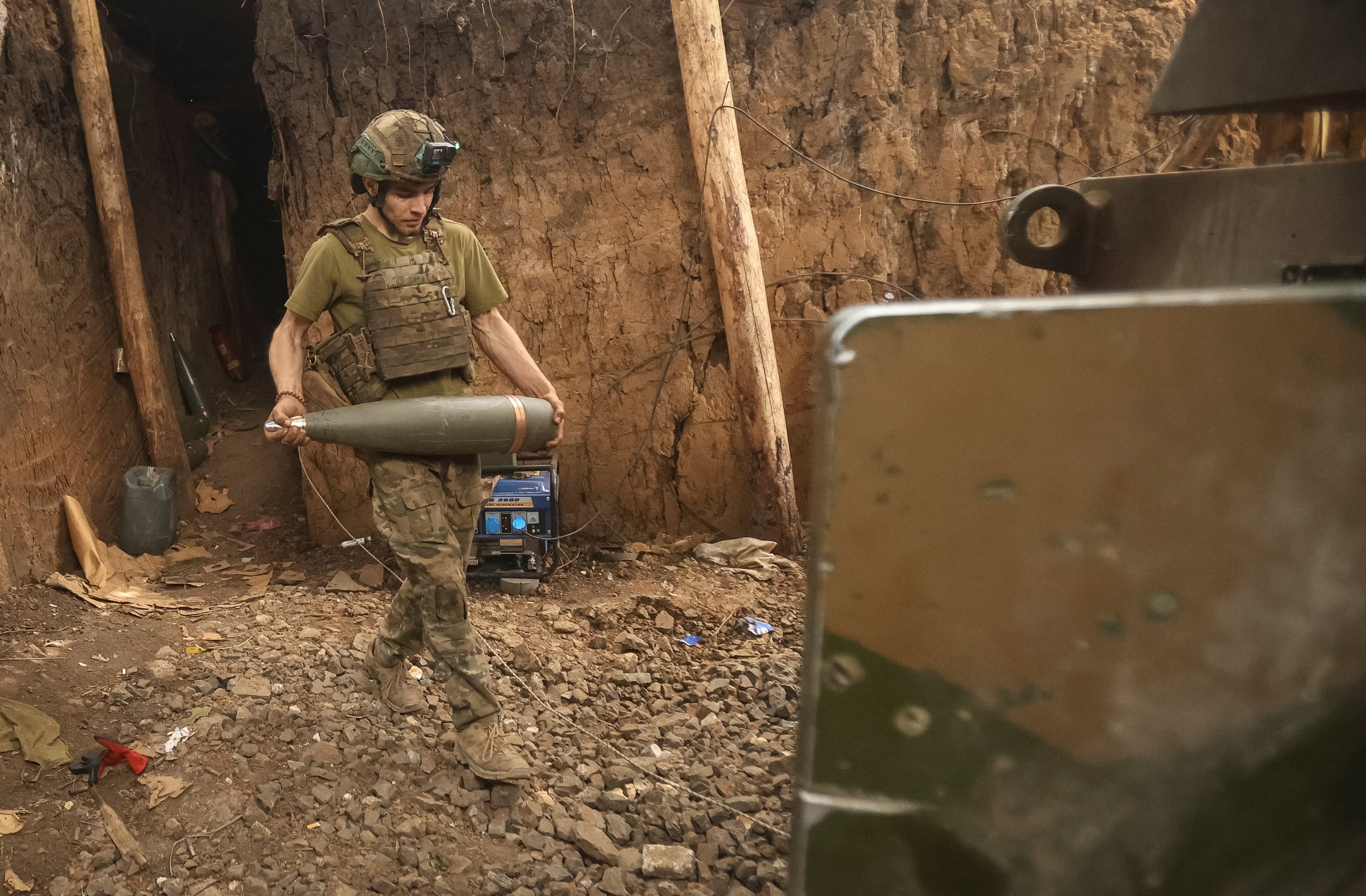A Ukrainian serviceman carrying an artillery shell. Photo: Reuters
