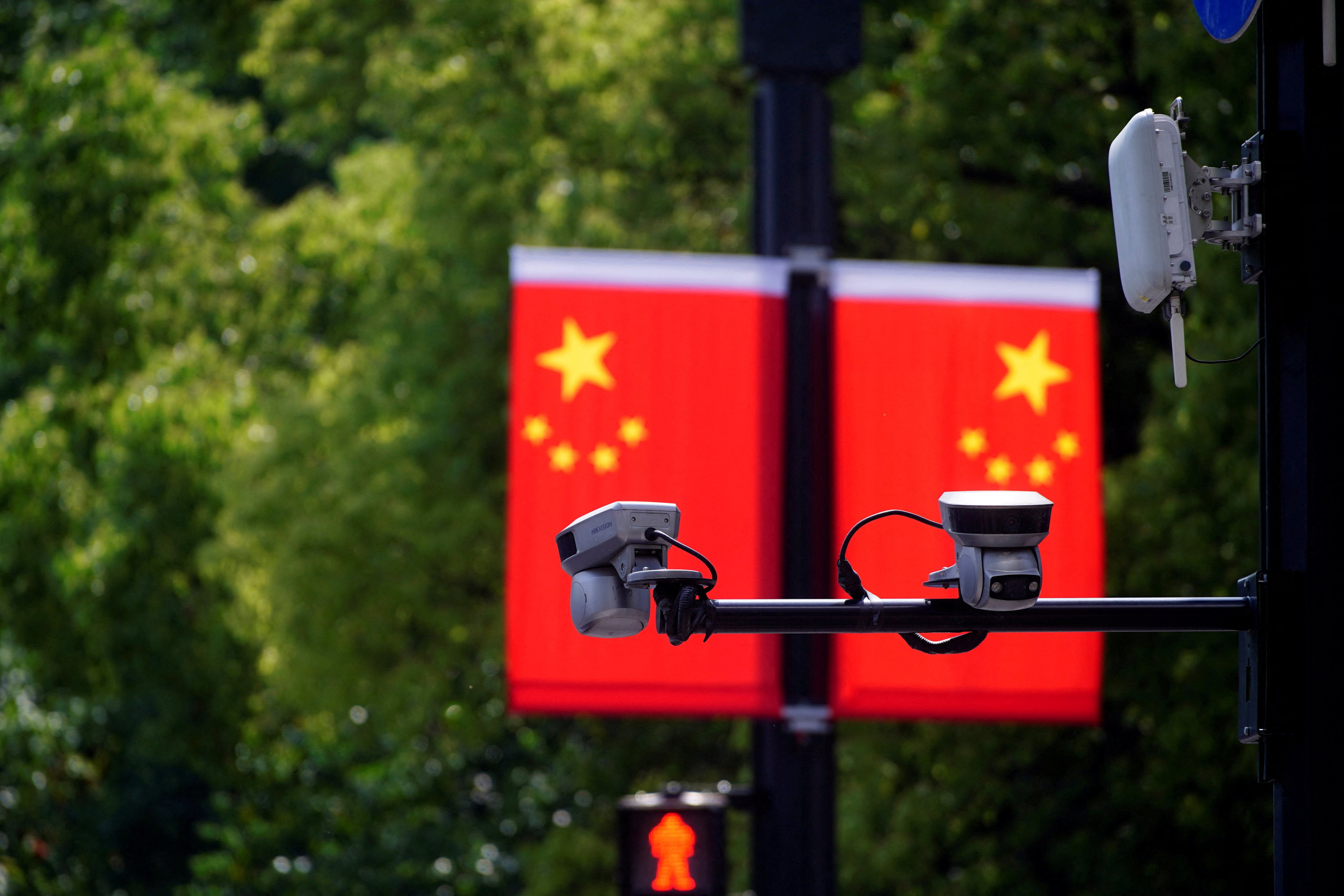 Hikvision surveillance cameras are seen in front of Chinese flags at a main shopping area in Shanghai on May 5, 2021. Photo: Reuters