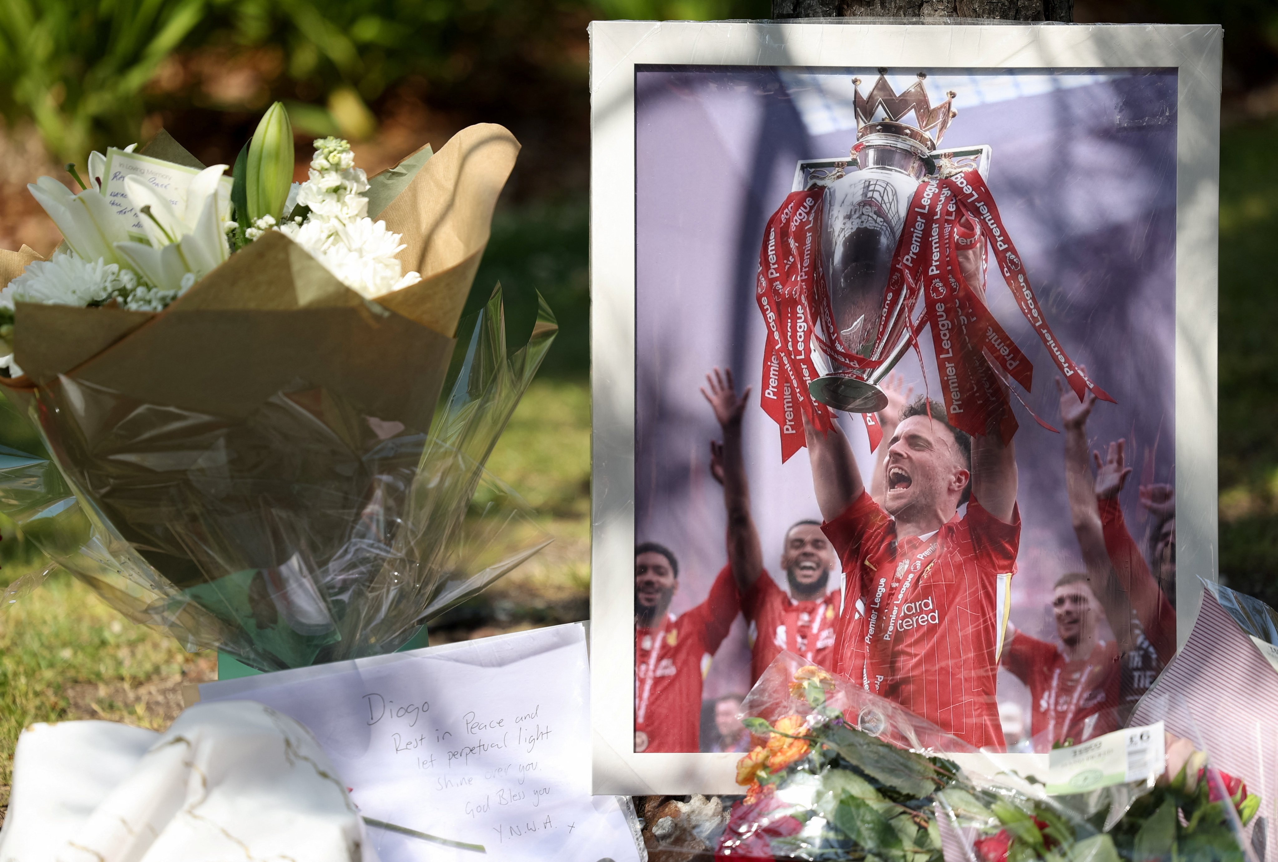 A picture of Liverpool’s Portuguese soccer player Diogo Jota stands next to flower tributes at Anfield. Photo: Reuters