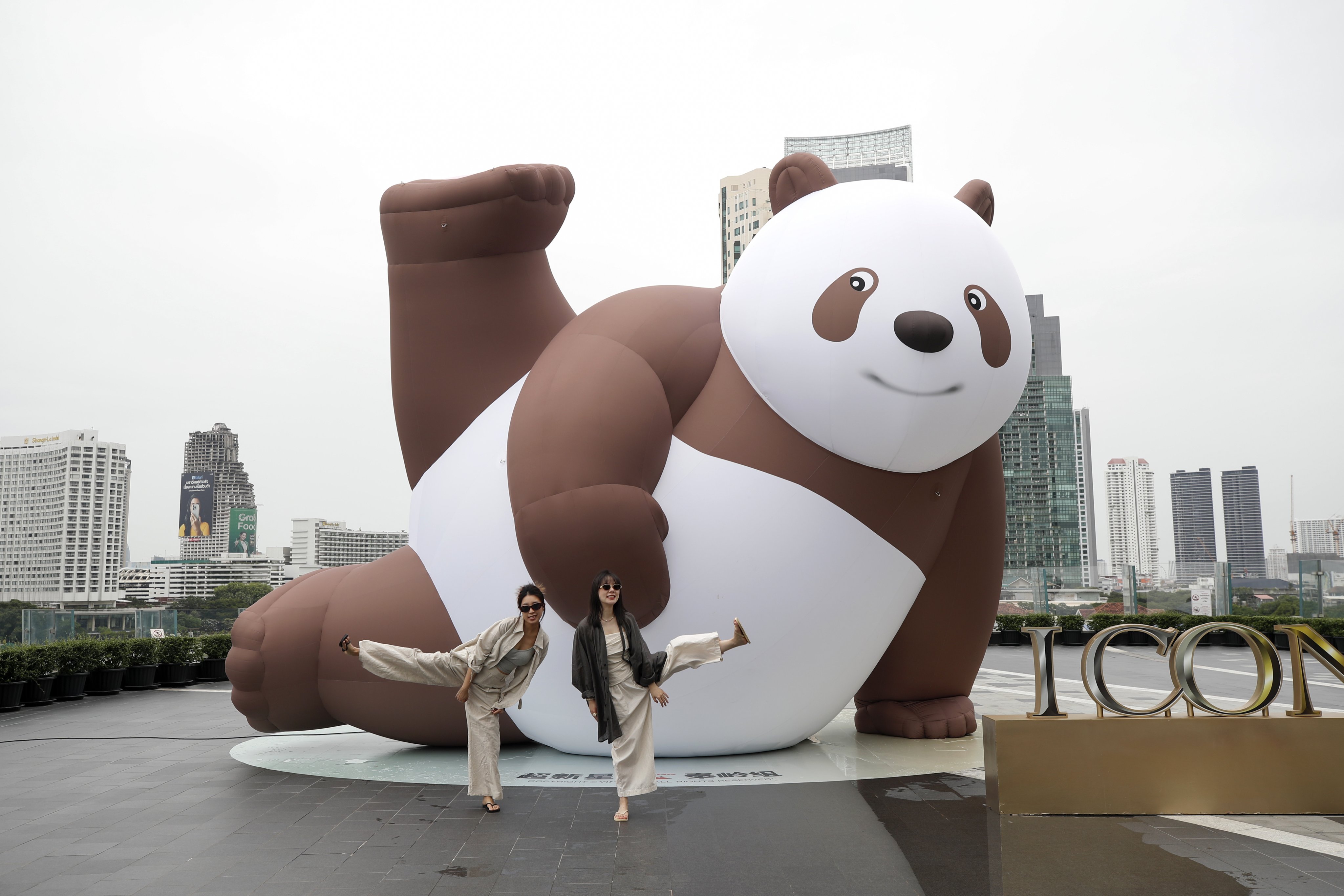 Tourists pose in front of an inflatable artwork in Bangkok, Thailand, on July 3. Photo: EPA