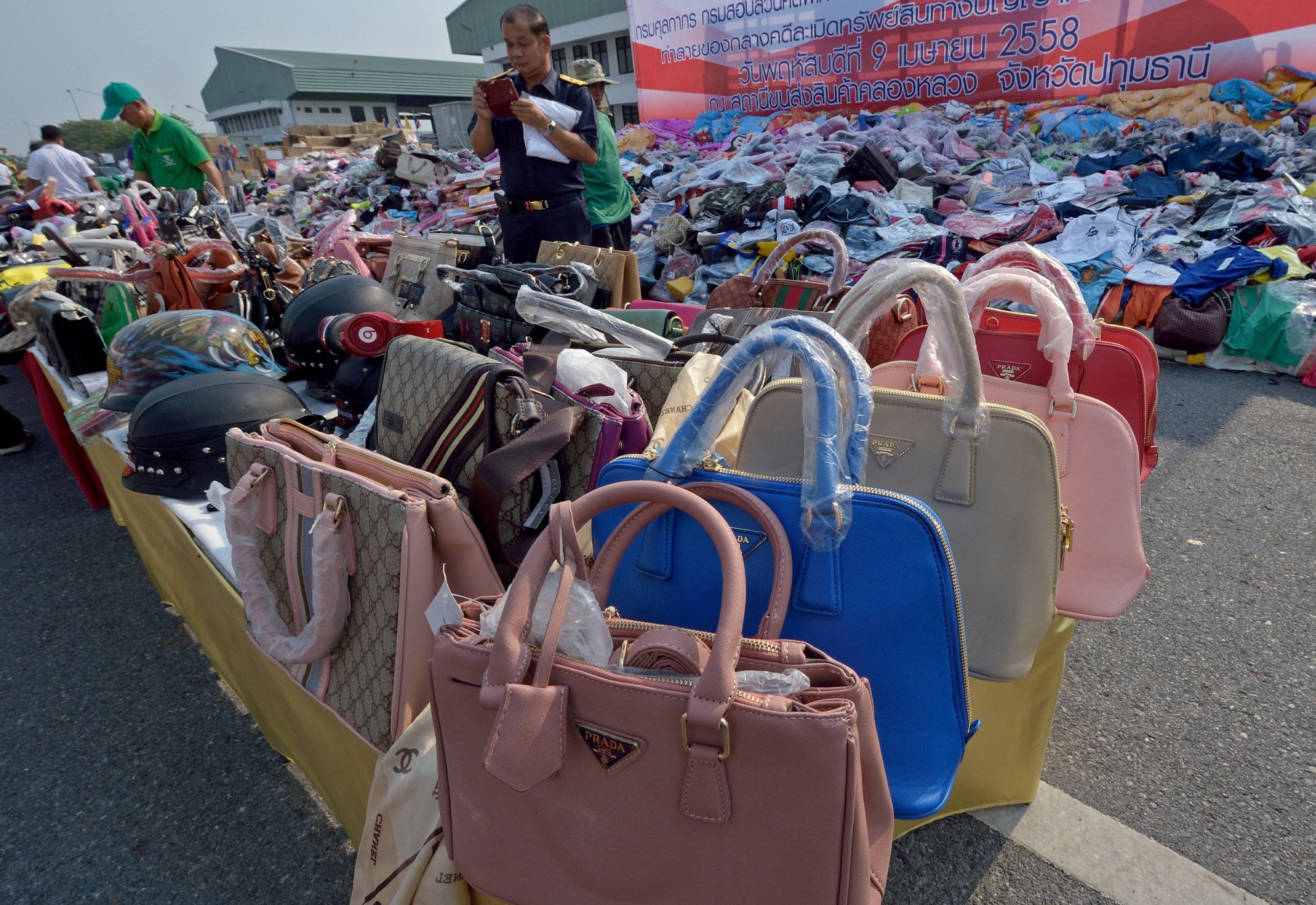 Thai officials inspect counterfeit goods during an event held to destroy fakes in Pathum Thani province. Photo: AFP Thai officials inspect counterfeit goods during an event held to destroy fakes in Pathum Thani province. Photo: AFP