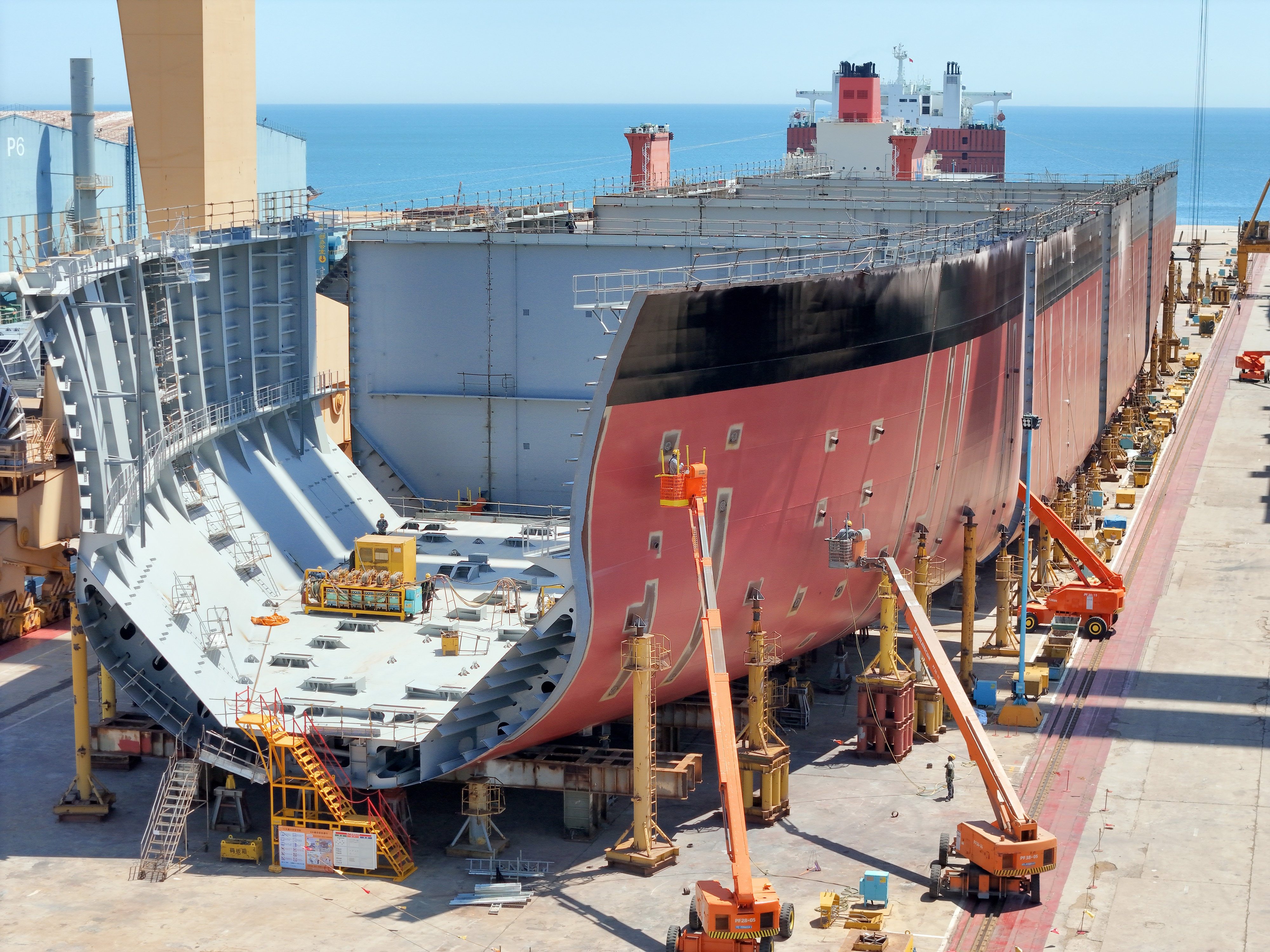 Workers build sections of the hull of a large ship on a ladder truck of a shipbuilding enterprise in Yantai city, Shandong province, China, on June 4, 2025. Photo: NurPhoto via Getty Images