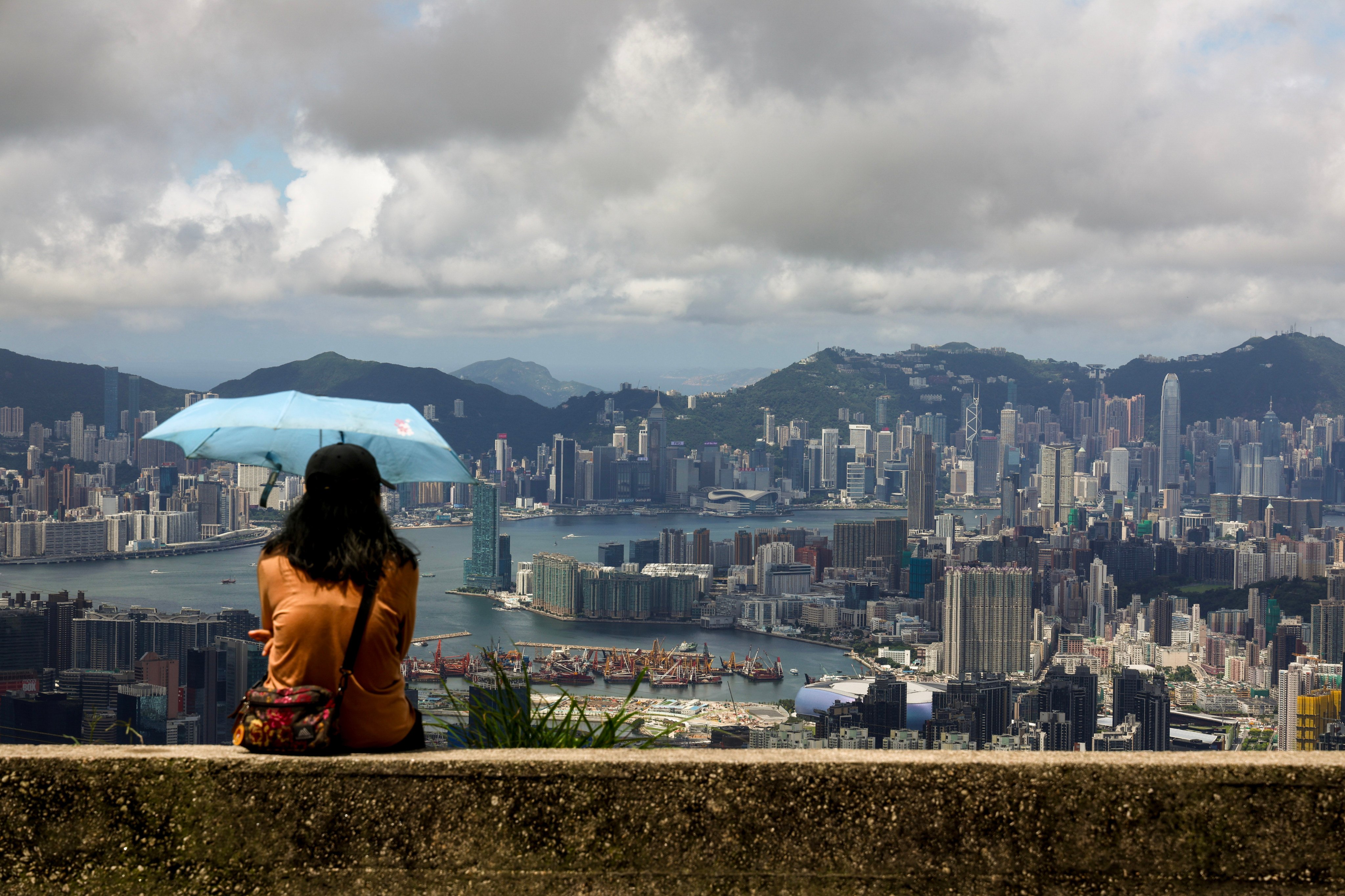 A woman stays under the shade of an umbrella at Kowloon Peak, or Fei Ngo Shan, on June 21. The world today faces many challenges, including climate change and pollution. Photo: Dickson Lee