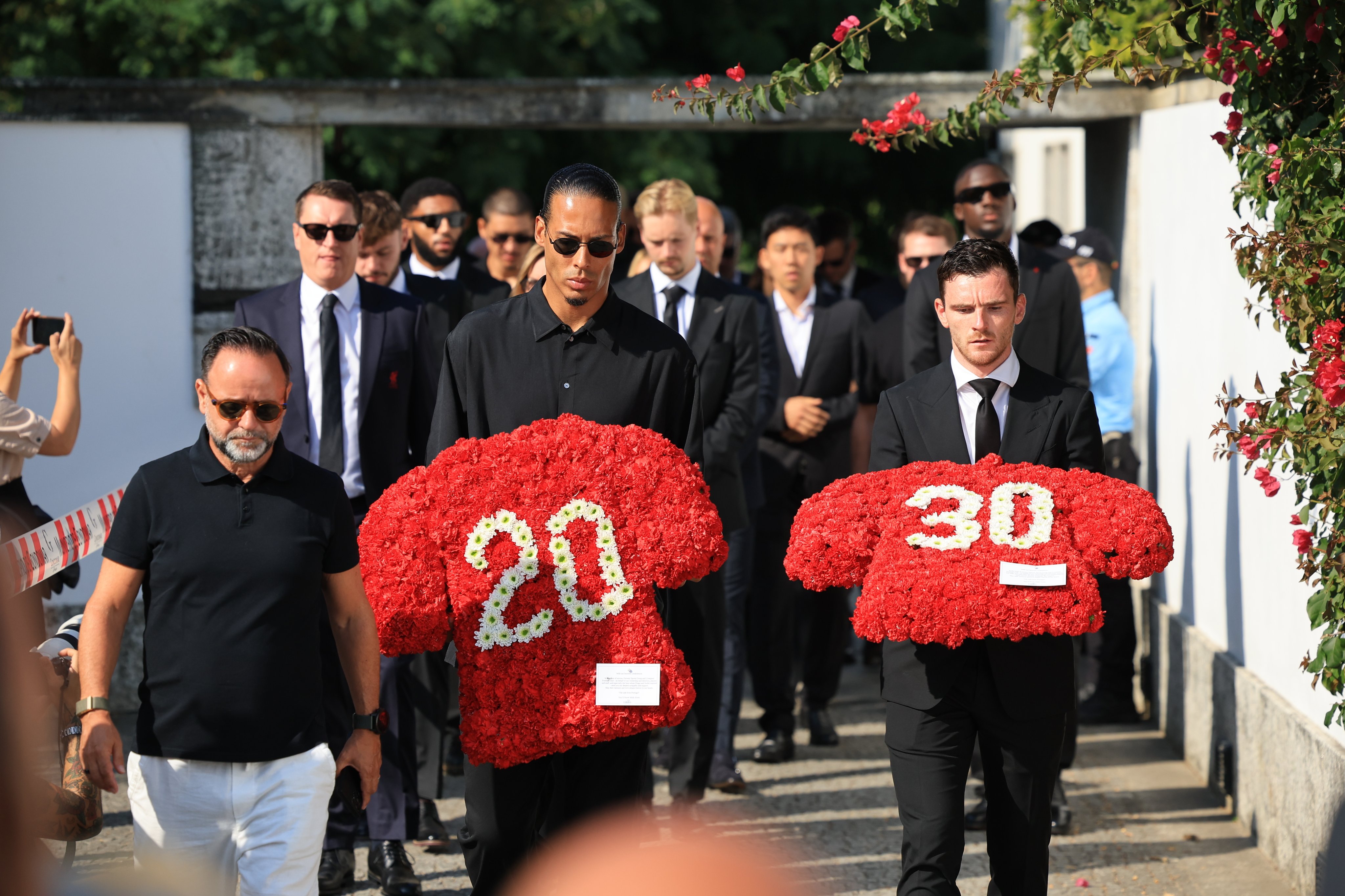 Liverpool players Virgil van Dijk (left) and Andrew Robertson carry floral tributes for the late Portuguese player Diogo Jota and his brother, Andre Silva, in Gondomar, Portugal on Saturday. Photo: EPA