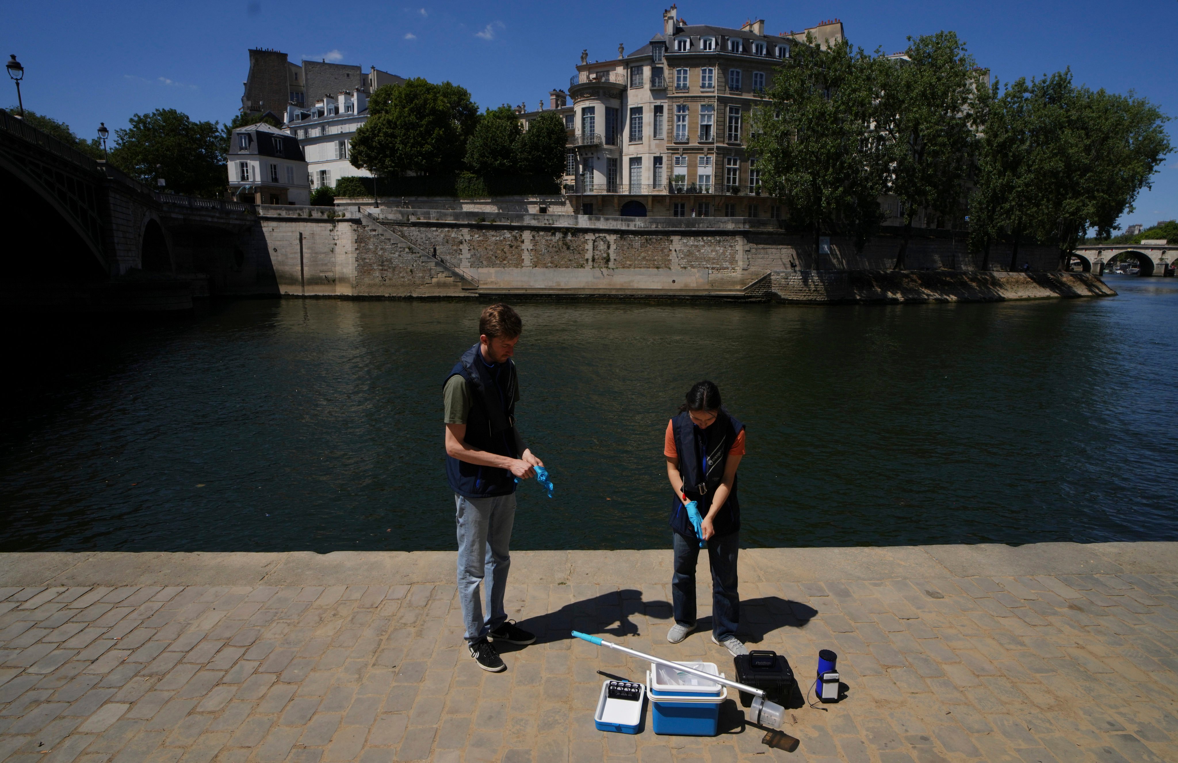 Fluidion workers test the Seine river water quality on Thursday, ahead of the opening of the three Seine swimming pools from Saturday to August 31 in Paris. Photo: AP