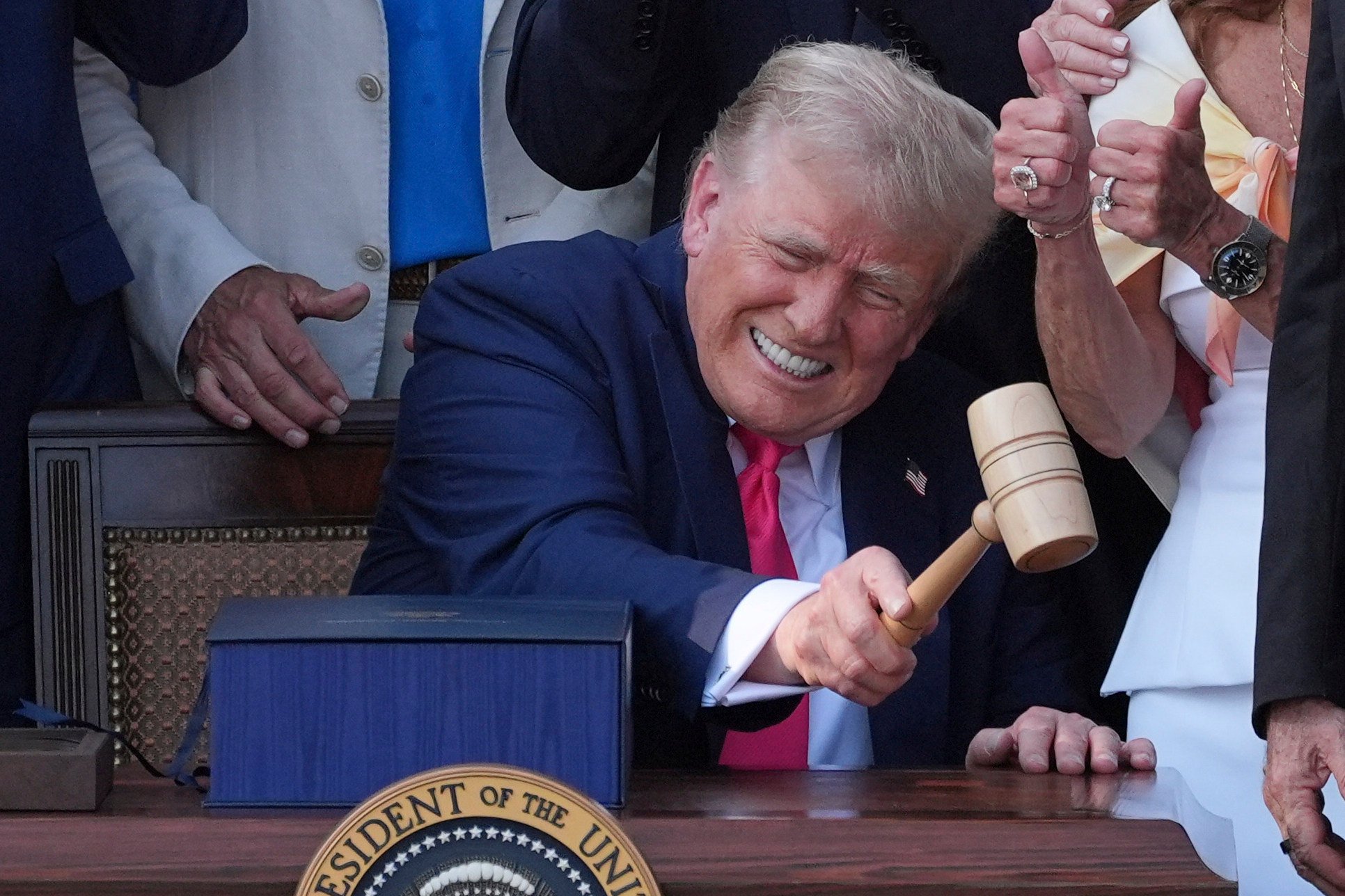 US President Donald Trump bangs a gavel presented to him by House Speaker Mike Johnson after he signed his signature bill of tax breaks and spending cuts at the White House on Friday. Photo: AP