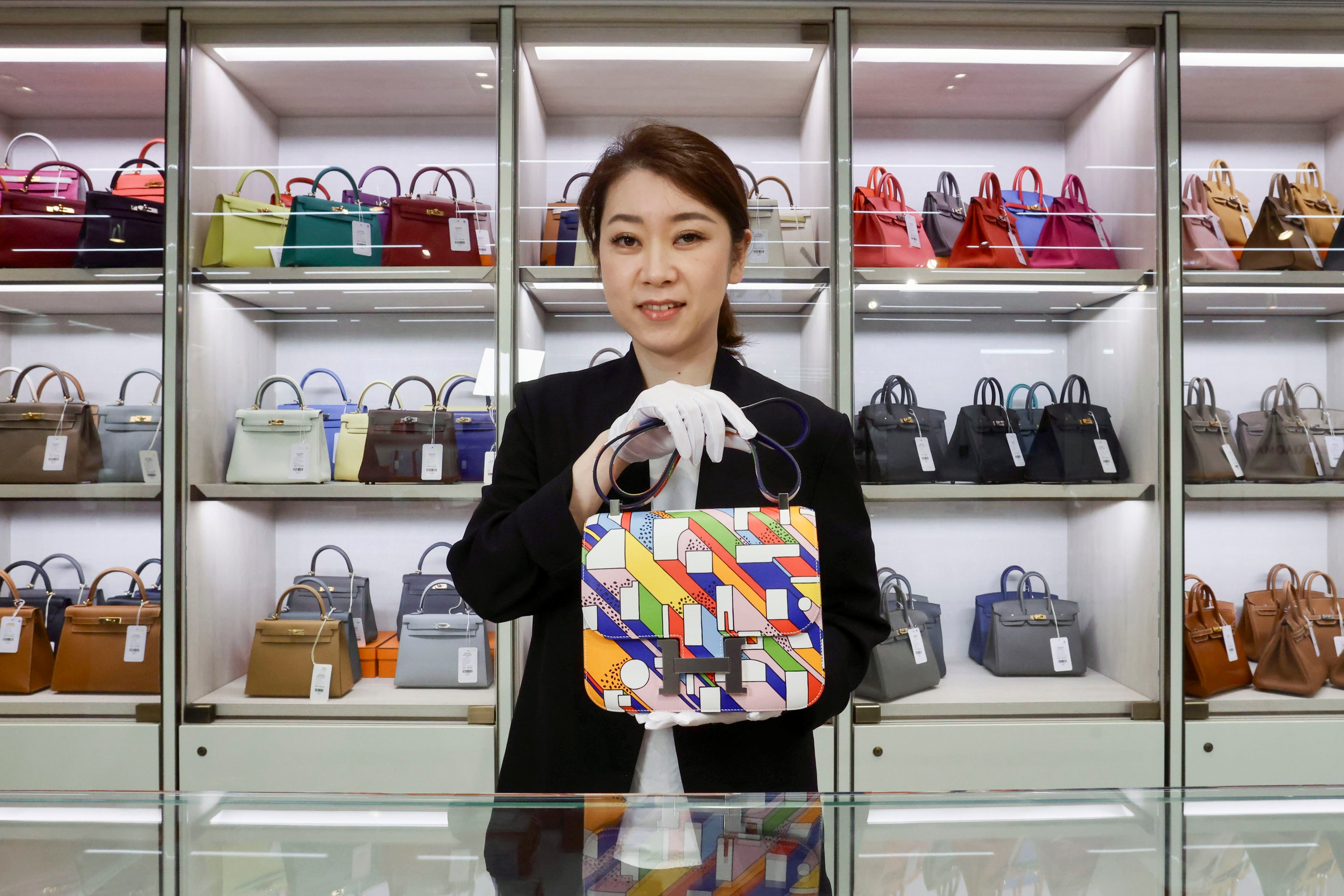 Noa Kurumada, overseas director of Ginza Xiaoma, displays a luxury item at the shop in New World Tower. Photo: Jonathan Wong