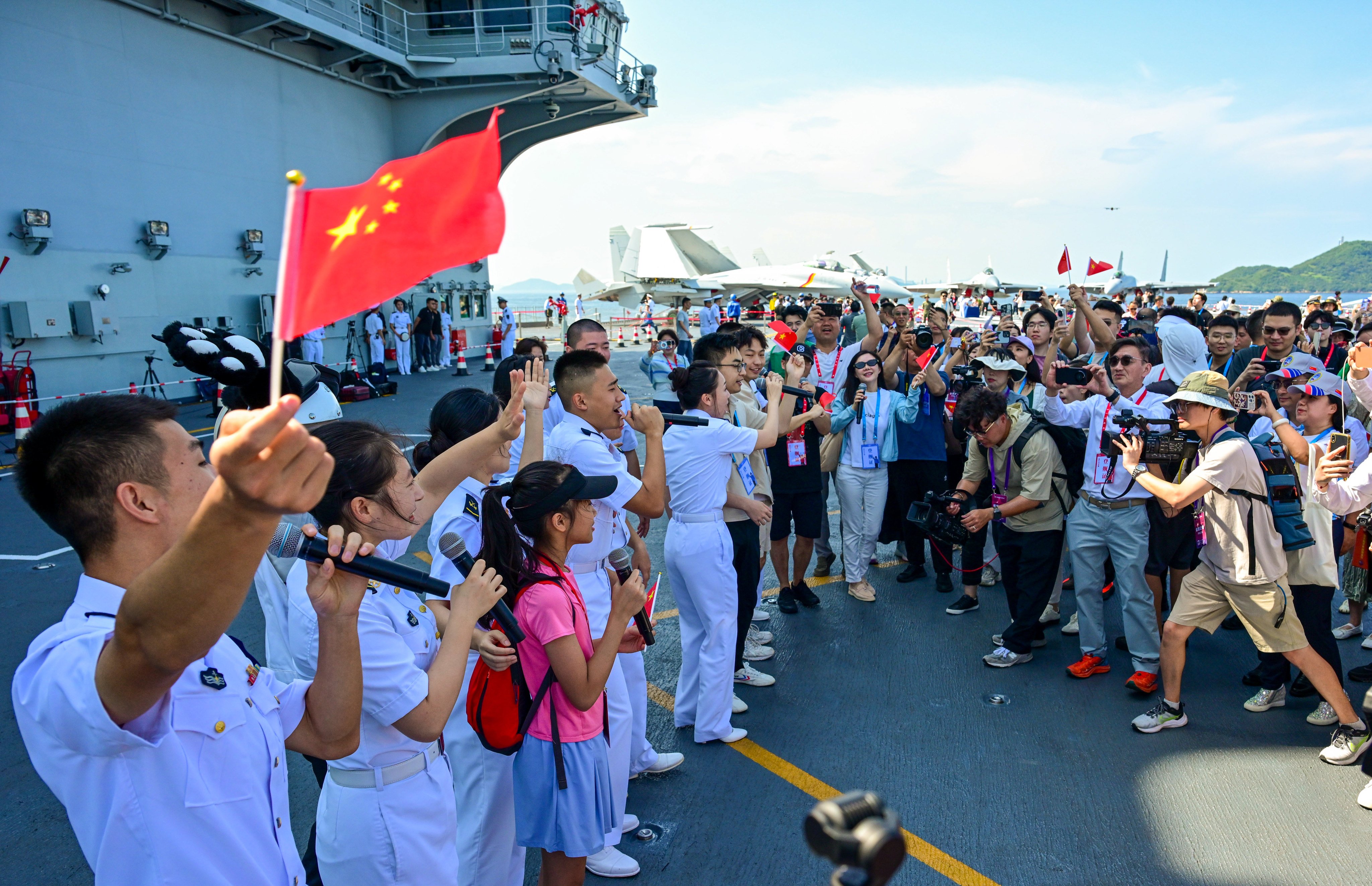 Crew members perform for visitors on the deck of the aircraft carrier Shandong in Hong Kong. Photo: Xinhua